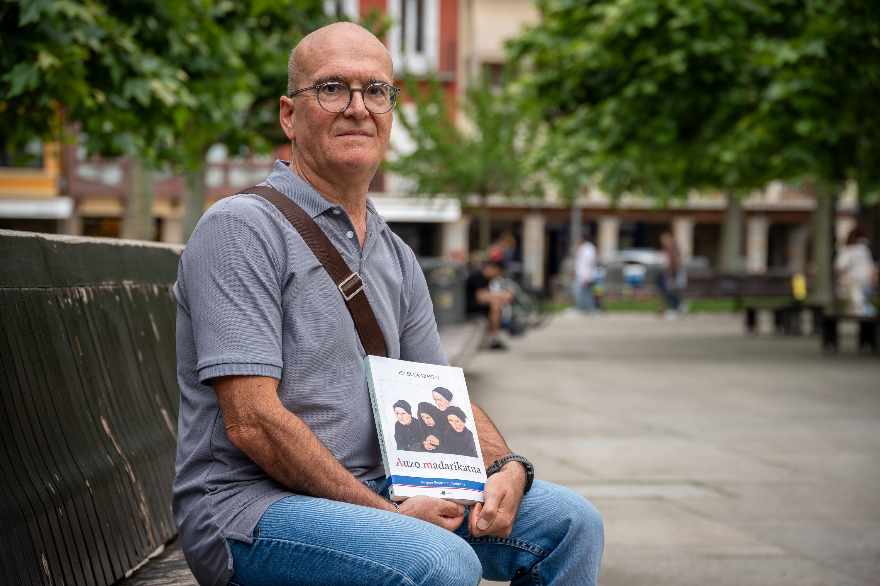 Aingeru Epaltza, 'Auzo madarikatua' liburua eskuetan, Iruñeko Gazteluko plazan. AITOR KARASATORRE / FOKU