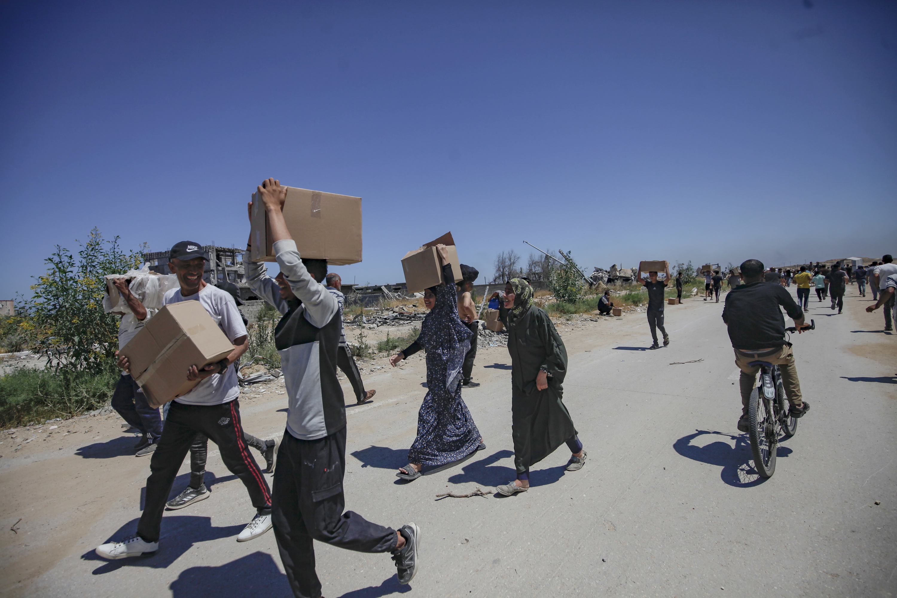 Palestinarrak laguntza humanitarioa jaso ostean, Netzarim pasabidetik hurbil (Gaza), maiatzaren 29an. HAITHAM IMAD / EFE