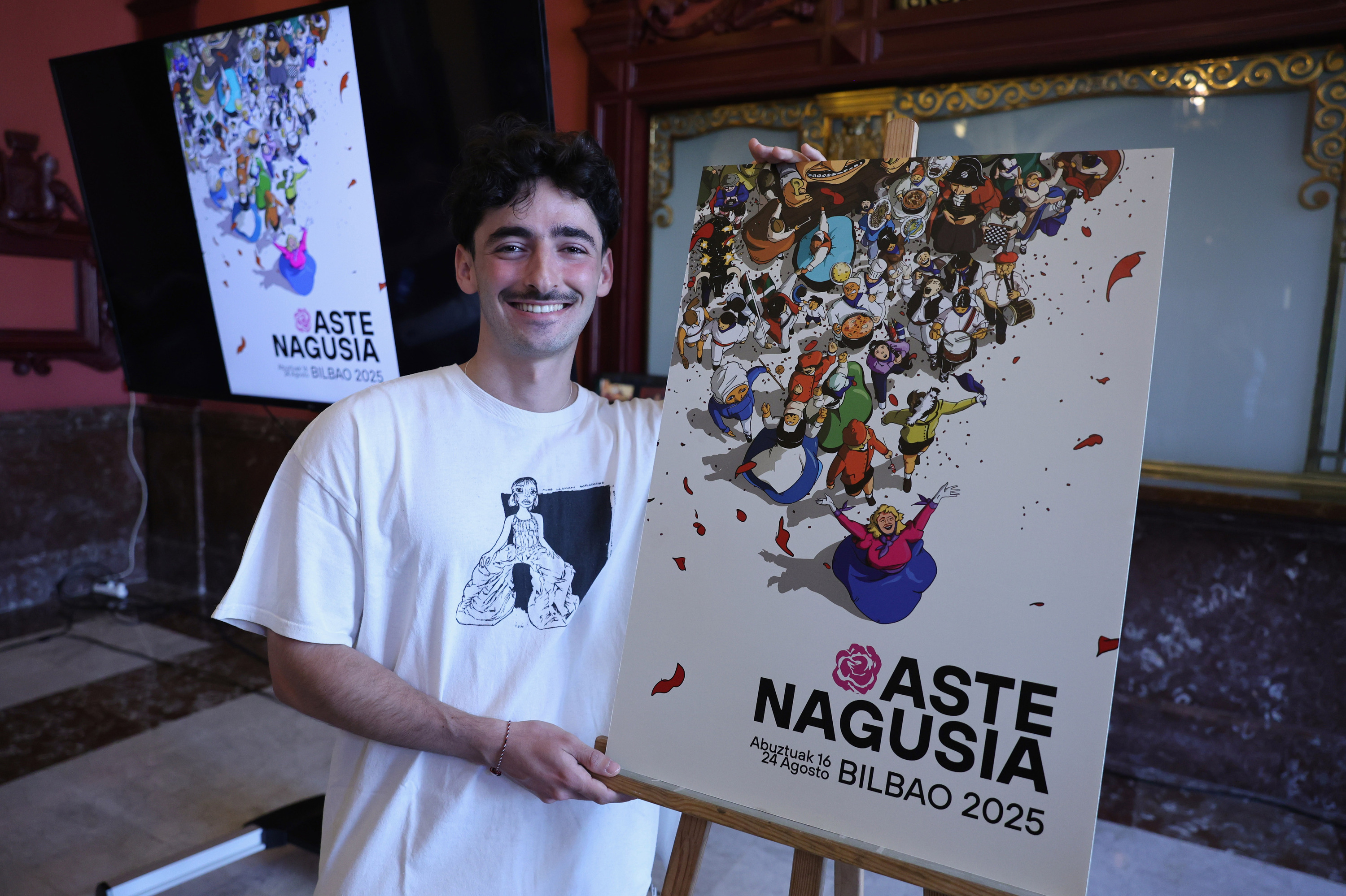 Mario Larrinaga, gaur goizean, Bilboko Aste Nagusiko kartel irabazlea eskuan duela. OSKAR MATXIN EDESA / FOKU