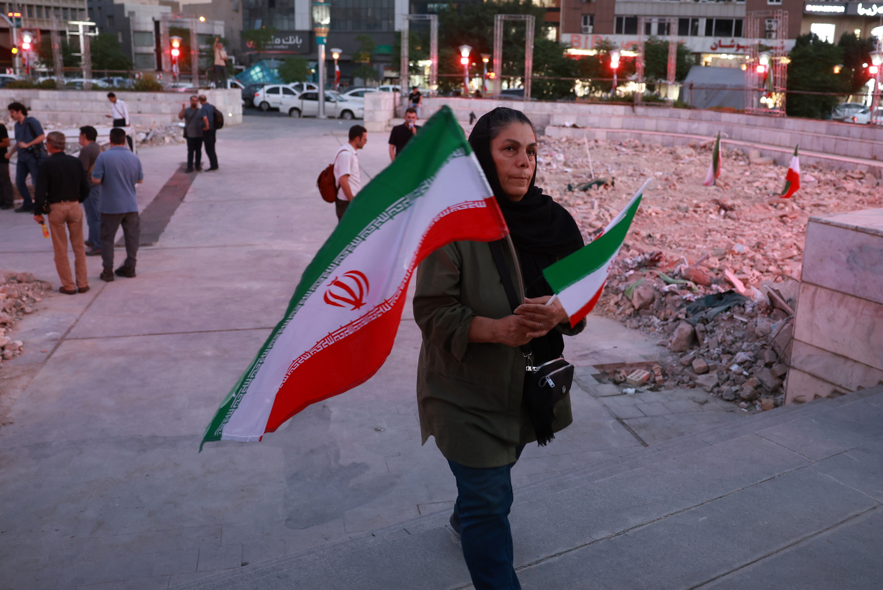 Emakume bat, Iranen bi bandera aldean daramatzala, astelehenean, Teheranen. ABEDIN TAHERKENAREH / EFE