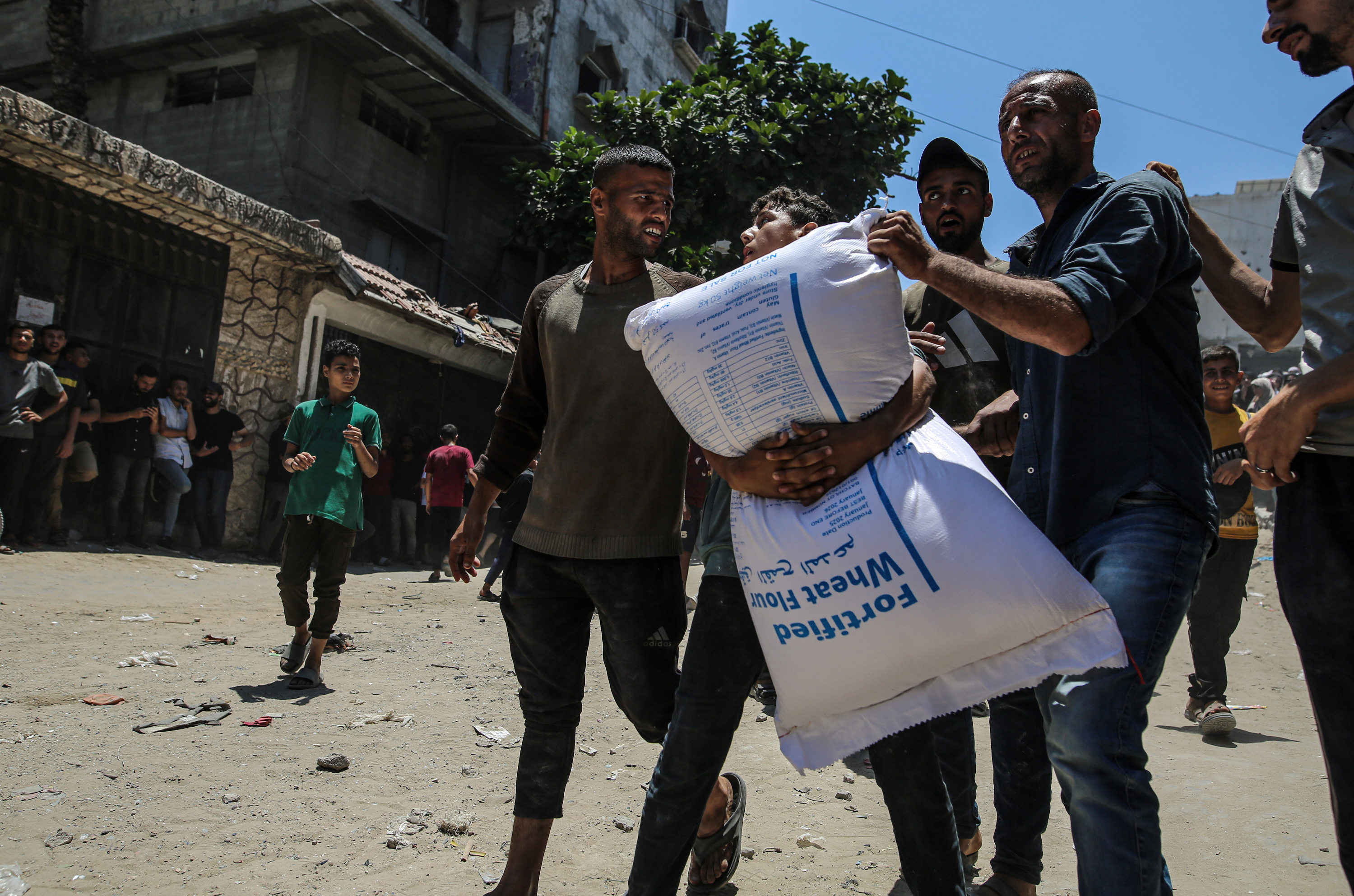 Bost gazatar laguntza humanitarioa jaso berri, Gaza hirian, ekainean. MOHAMMED SABER / EFE