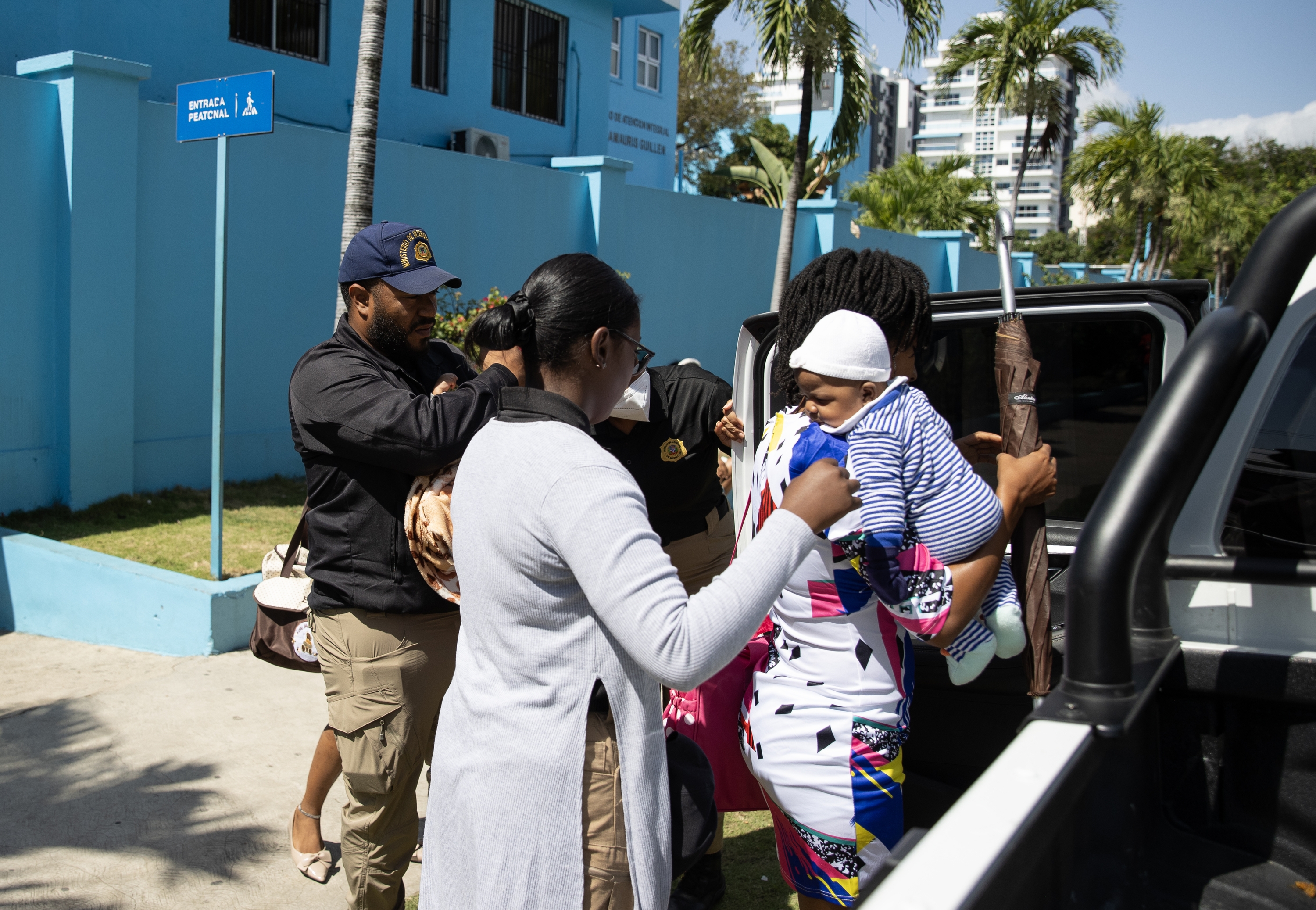 Bi emakume haitiar beren umeekin migrazio poliziaren auto batean sartzen, Santo Domingoko ospitale bateko sarreran, apirilaren 21ean, neurria ezarri zen egunean. ORLANDO BARRIA / EFE