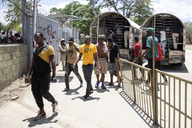 Zenbait haitiar, migrazio poliziaren kamioietatik jeisten, Elías Piñan, bi herrialdeen arteko mugan, apirilean. ORLANDO BARRÍA / EFE Zenbait haitiar, migrazio poliziaren kamioietatik jeisten, Elías Piñan, bi herrialdeen arteko mugan, apirilean. ORLANDO BARRÍA / EFE