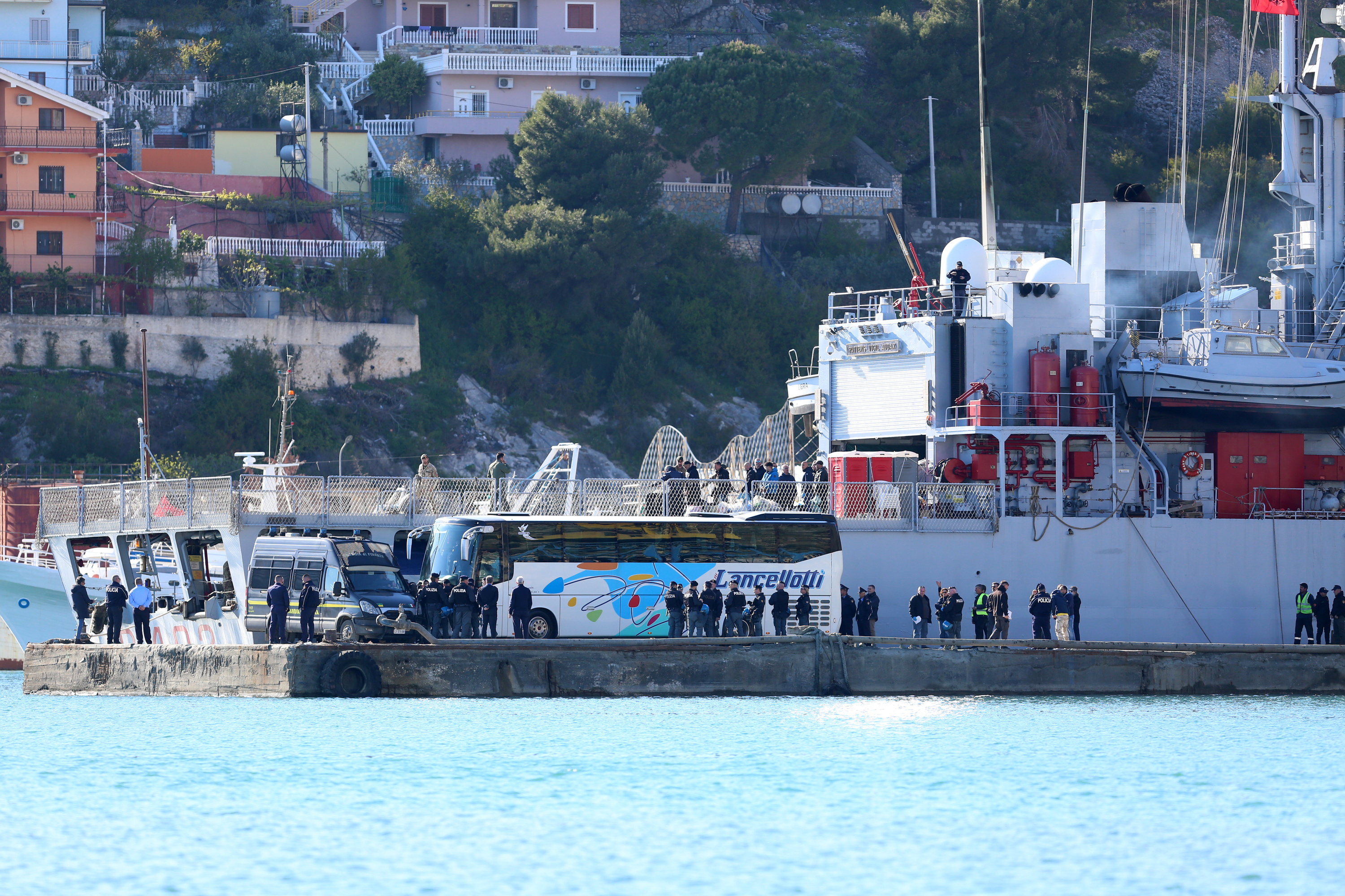 Migranteak daramatzan Italiako armadaren ontzi bat, Albaniako portu batean, apirilean. MALTON DIBRA / EFE