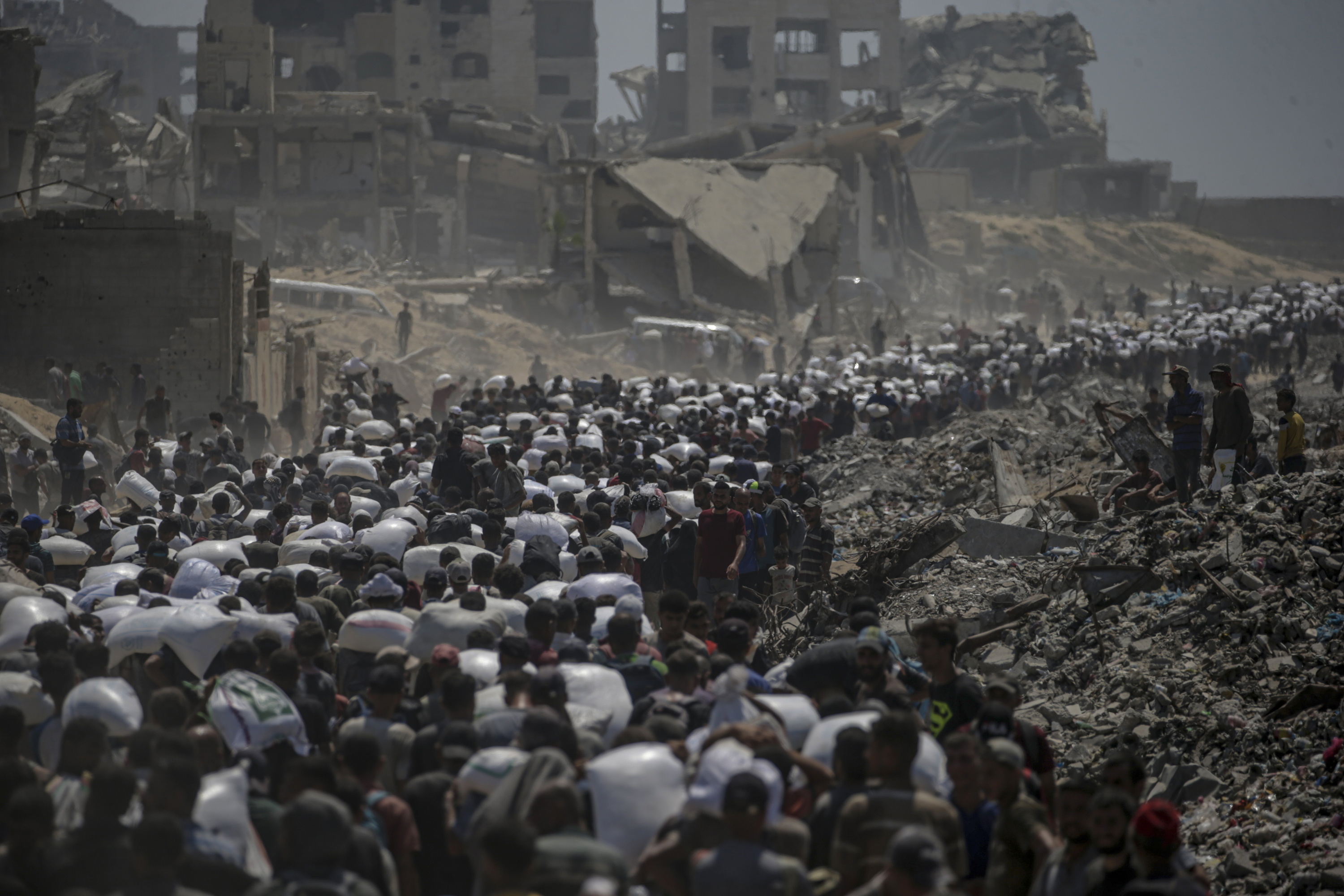Hainbat palestinar laguntza humanitarioa banatzen duten gune batetik bueltan, aurreko igandean, Gaza hiritik hurbil. MOHAMMED SABER / EFE
