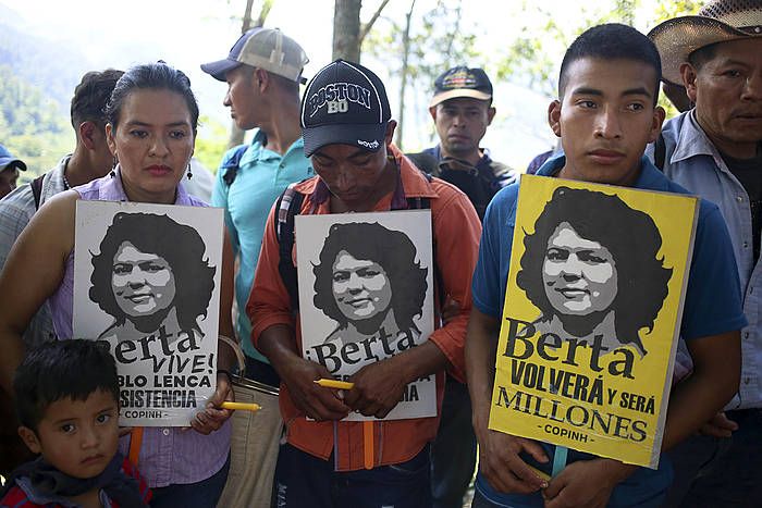 Lenca komunitate indigenako hainbat kide, Berta Caceres ekintzaile ekologistaren irudia duten kartelak eusten, 2017ko urrian, Hondurasko Rio Blanco komunitatean. GUSTAVO AMADOR, EFE