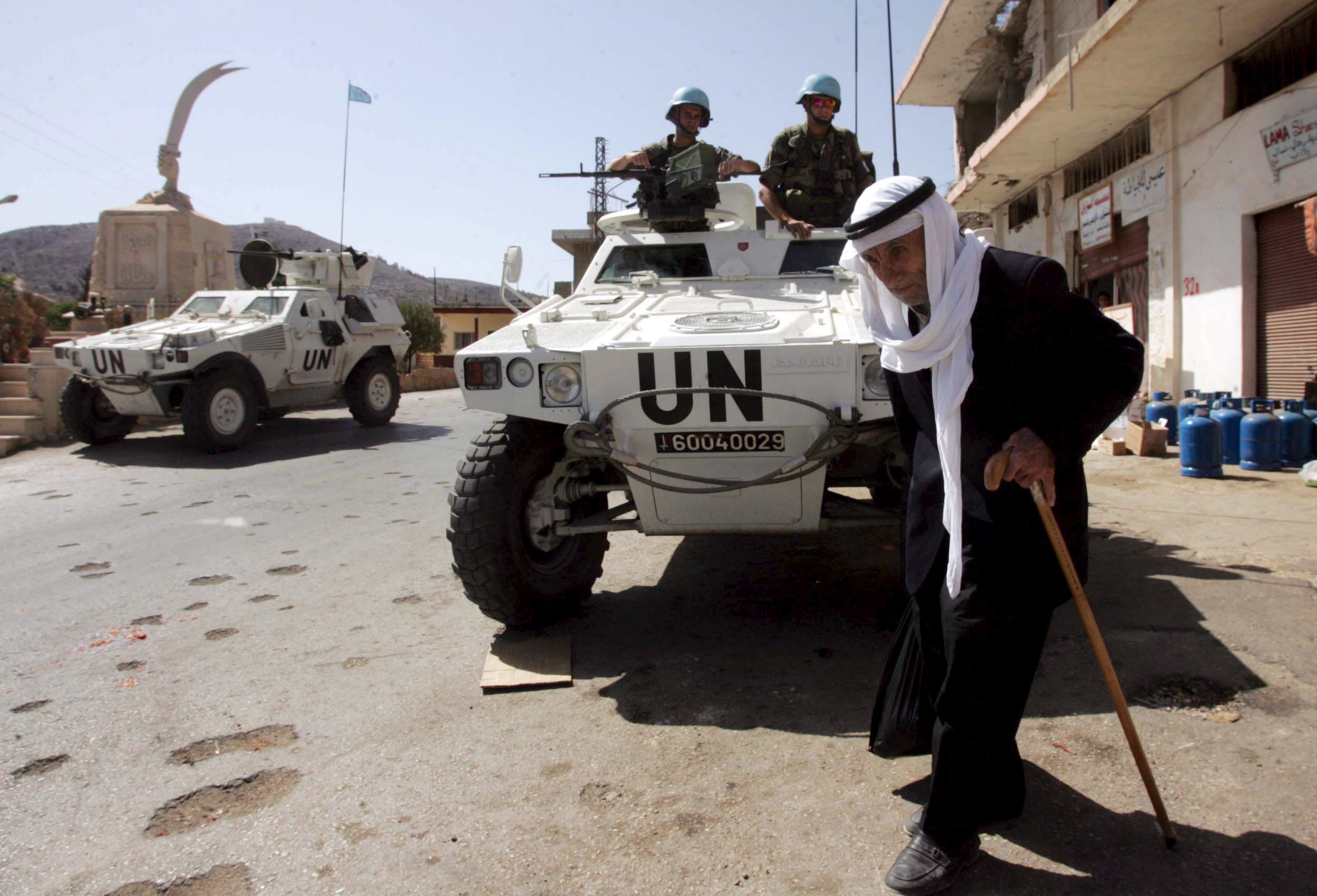 Gizonezko bat Unifil misioko kasko urdinen parean, Libanoko Ait Aroun herrian, maiatzean. MOHAMED MESSARA / EFE