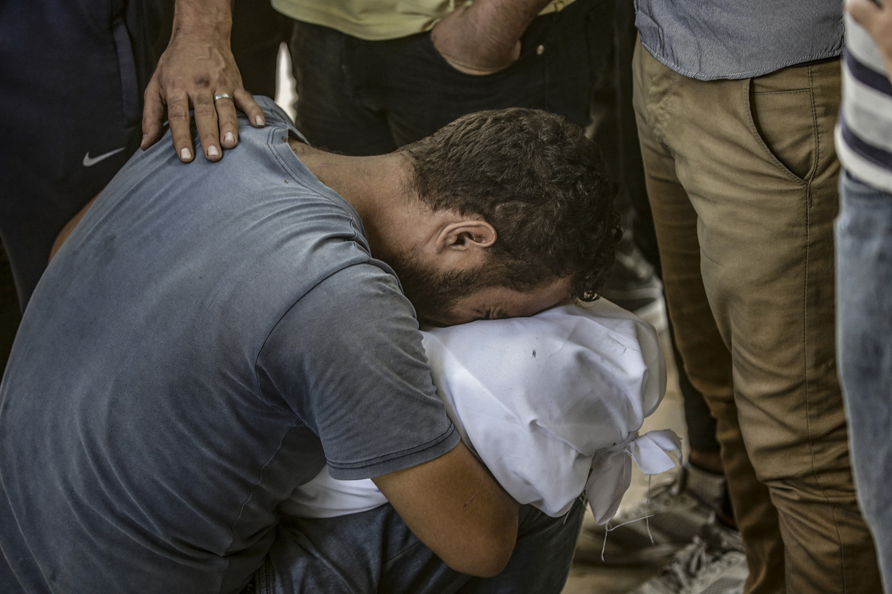 Pertsona bat, Israelek hildako baten gorpua besoetan duela, gaur, Gaza hirian. MOHAMMED SABER / EFE 