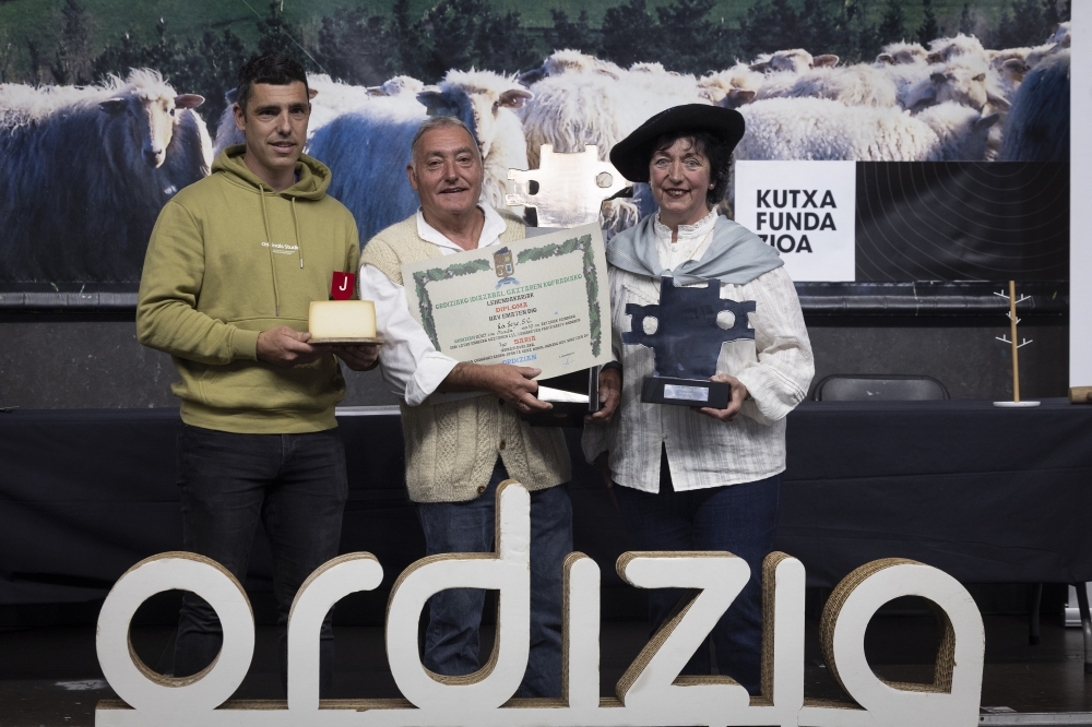 La Leze gaztandegiko Arkaitz Jauregi, Jose Mari Jauregi eta Eli Gorrotxategi, garaikurrekin, Ordiziako euskal jaietako azoka berezian. JAVIER ETXEZARRETA / EFE 