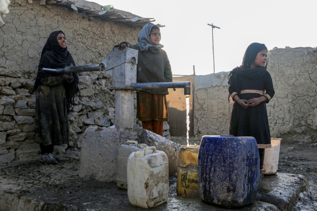 Hiru afganiar putzu bateko ura hartzen, iazko urtarrilean, Kabulen. SAMIULLAH POPAL / EFE