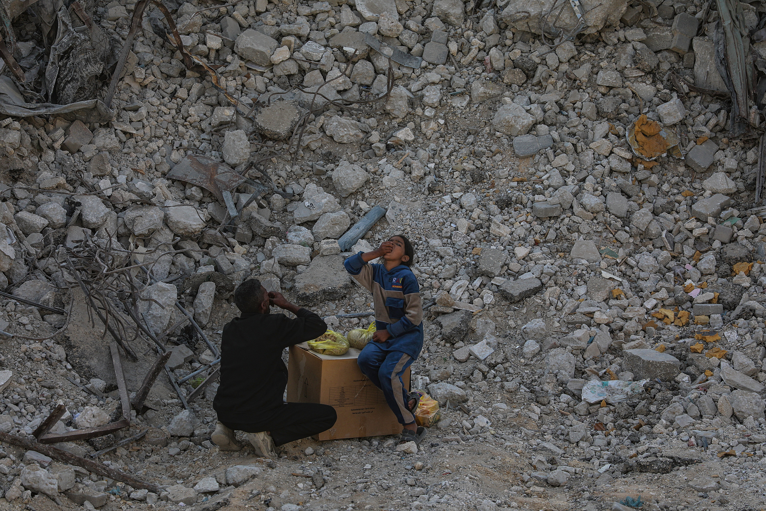 Bi palestinar jaten, atzo, Gaza hiriko hondakinen artean. MOHAMMED SABER / EFE Bi palestinar jaten, atzo, Gaza hiriko hondakinen artean. MOHAMMED SABER / EFE