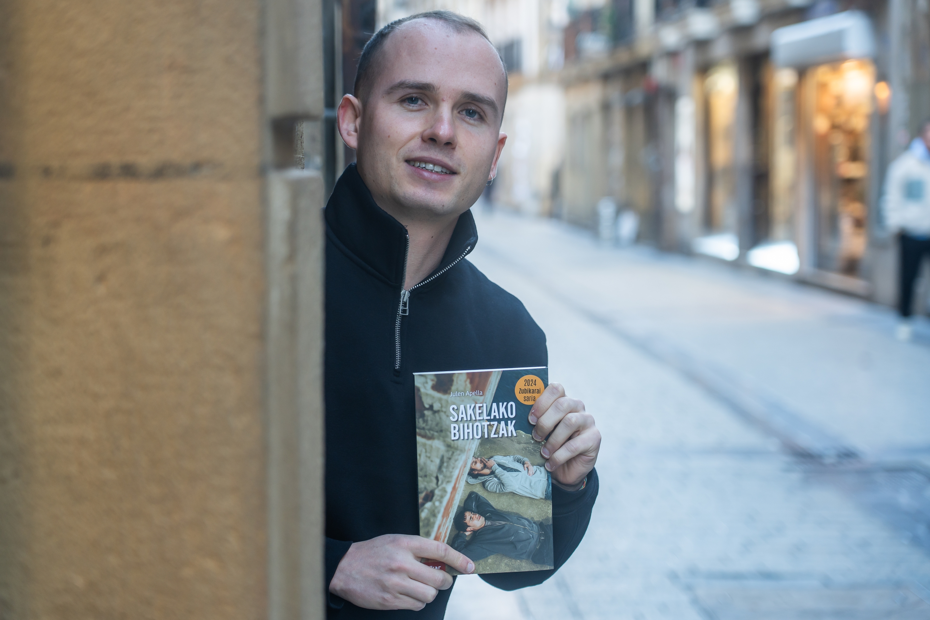 Julen Apella, 'Sakelako bihotzak' nobela eskuetan duela, Donostian. ANDONI CANELLADA / FOKU
