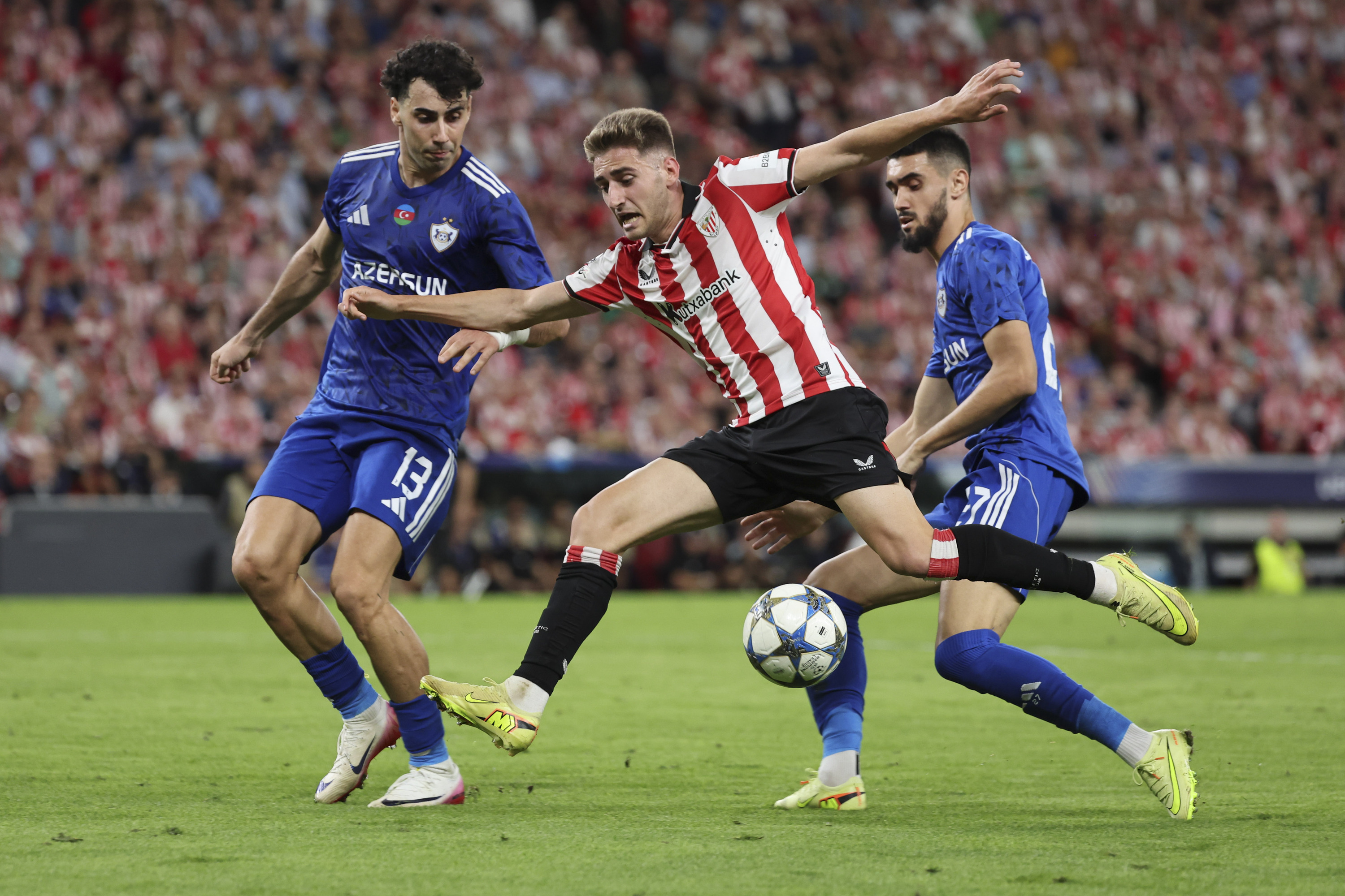 Robert Navarro baloia eraman nahian, Karabakheko bi jokalariren artean. LUIS TEJIDO / EFE