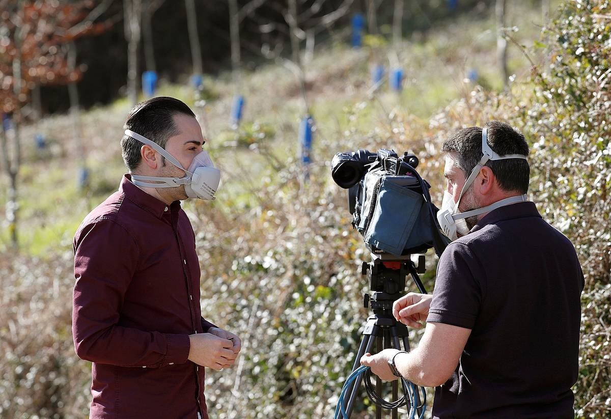 Telebista kate bateko bi langilek, Zaldibarko zabortegiaren inguruan, airetik babesteko maskarak jarrita. JUAN HERRERO, EFE