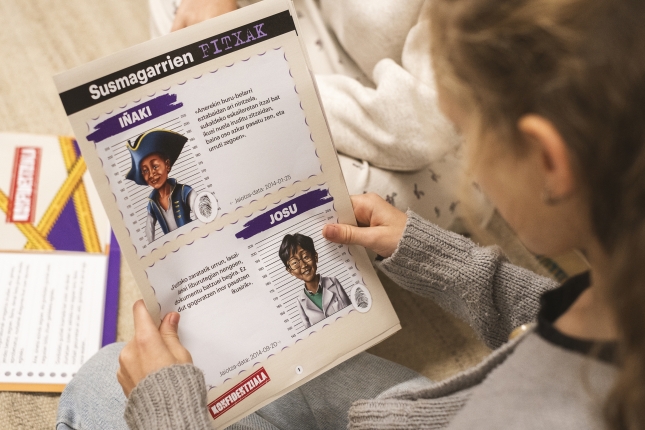 Haur bat Kasu laburrak jolaseko fitxa bat irakurtzen. MENDI URRUZUNO