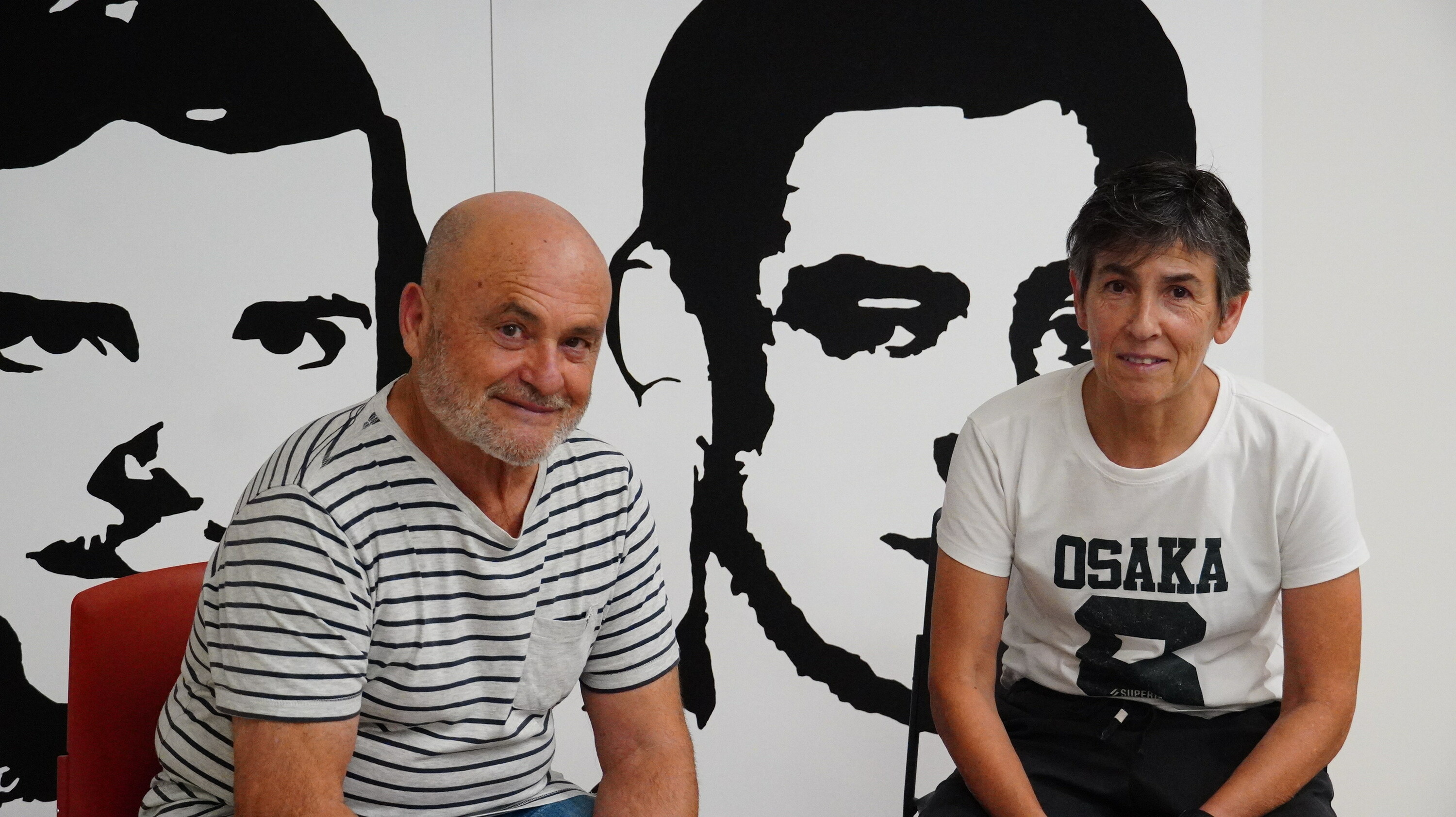 Mikel Paredes Txikiren anaia eta Mertxe Urtuzaga Otaegiren lehengusina, haien irudien aurrean. BERRIA