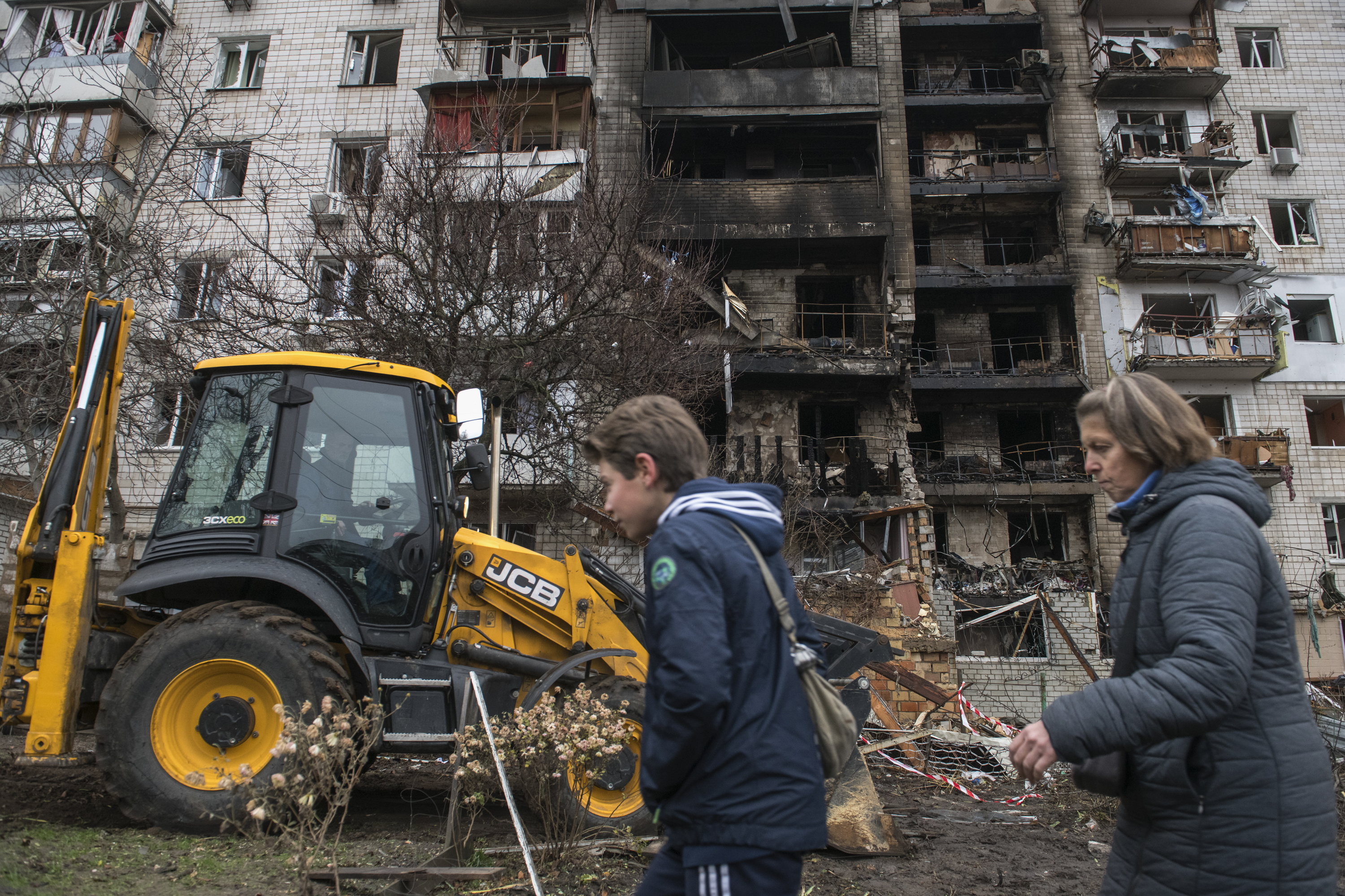Bi pertsona txikitutako eraikin baten paretik pasatzen Kieven, aurreko astean. MAXIM MARUSENKO / EFE