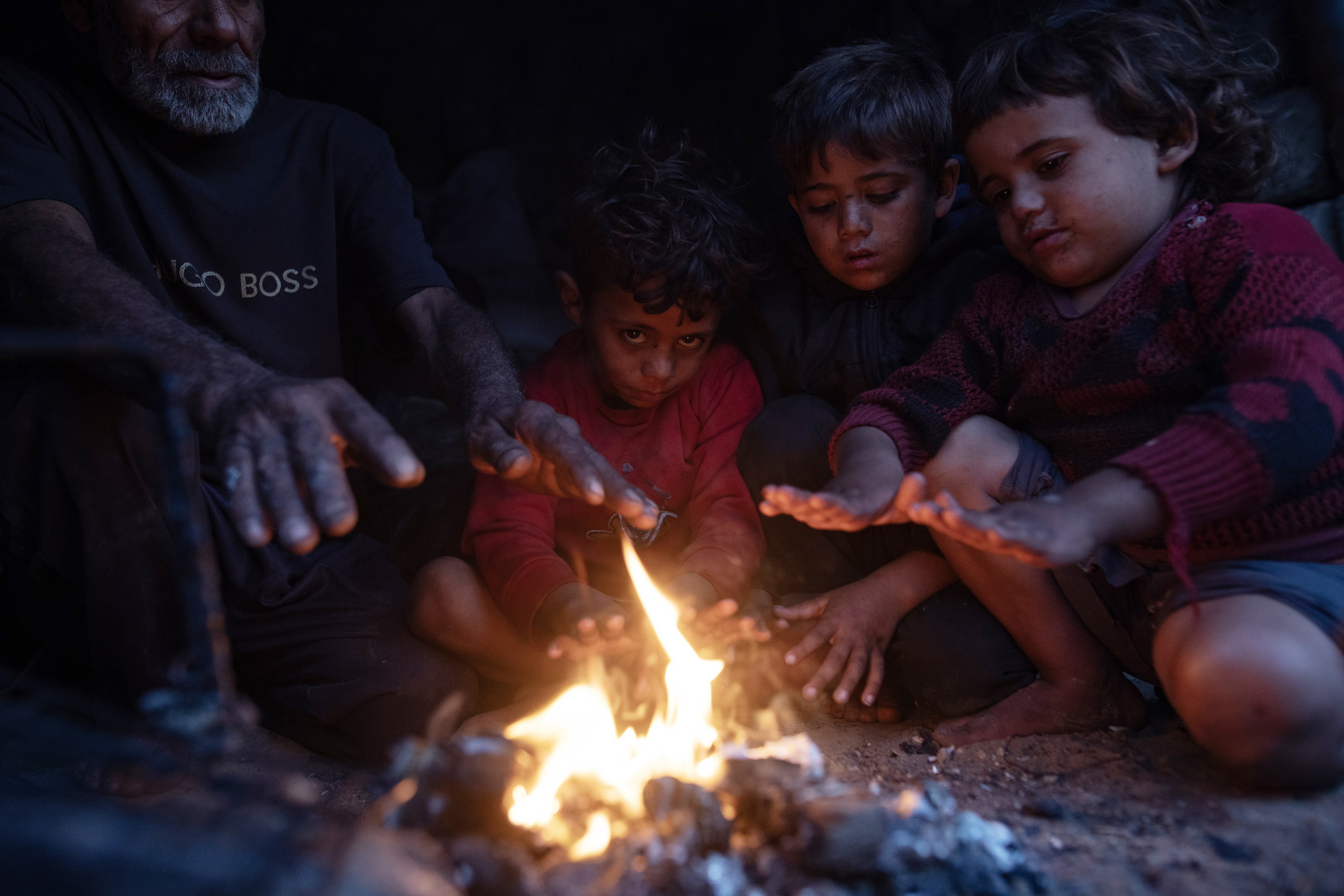 Palestinako familia bat, atzo, Gazan, suaren aldamenean. HAITHAM IMAD / EFE