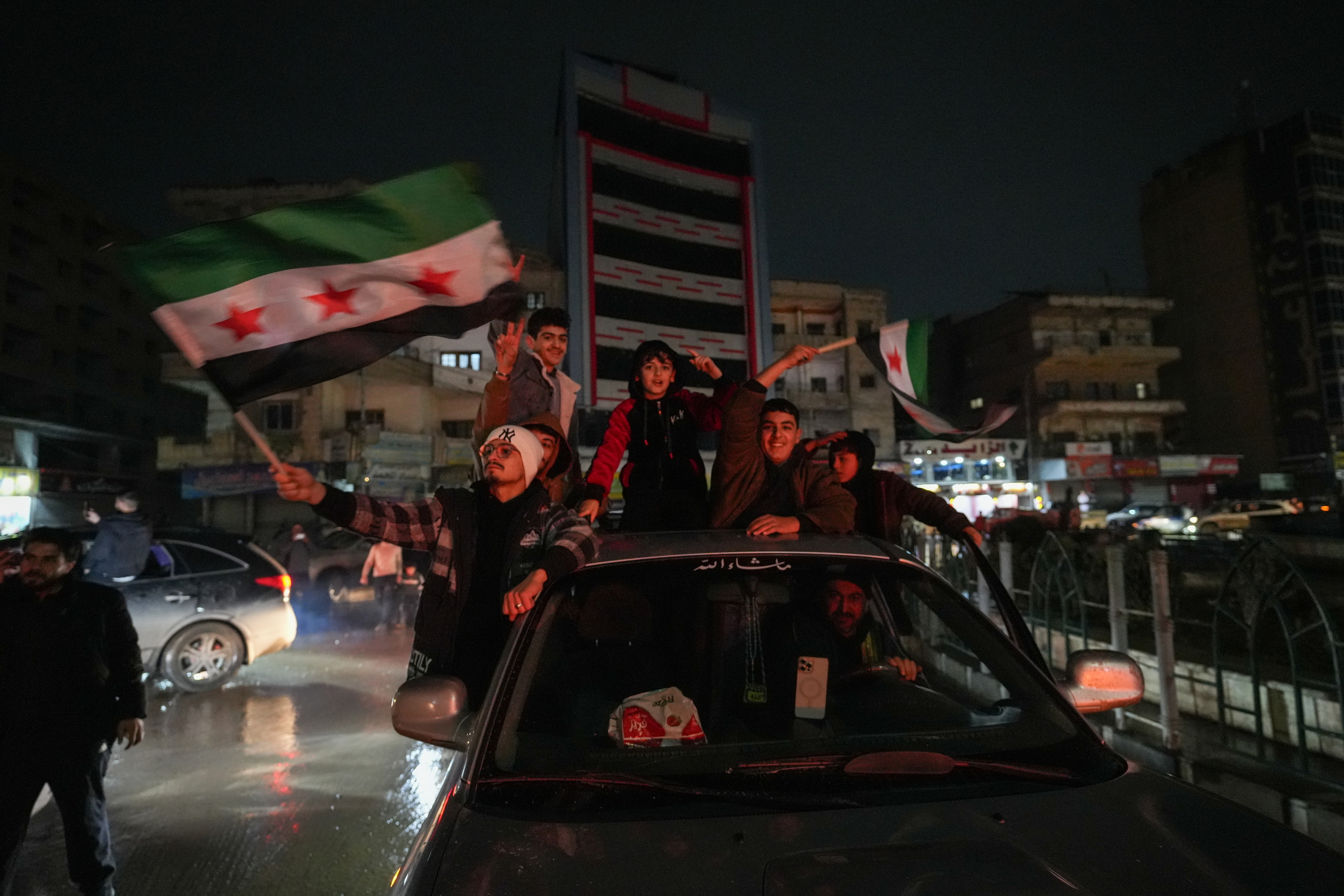 Pertsona batzuk atzo Raqqan, Siriako bandera eskuetan dutela.  AHMAD FALLAHA / EFE