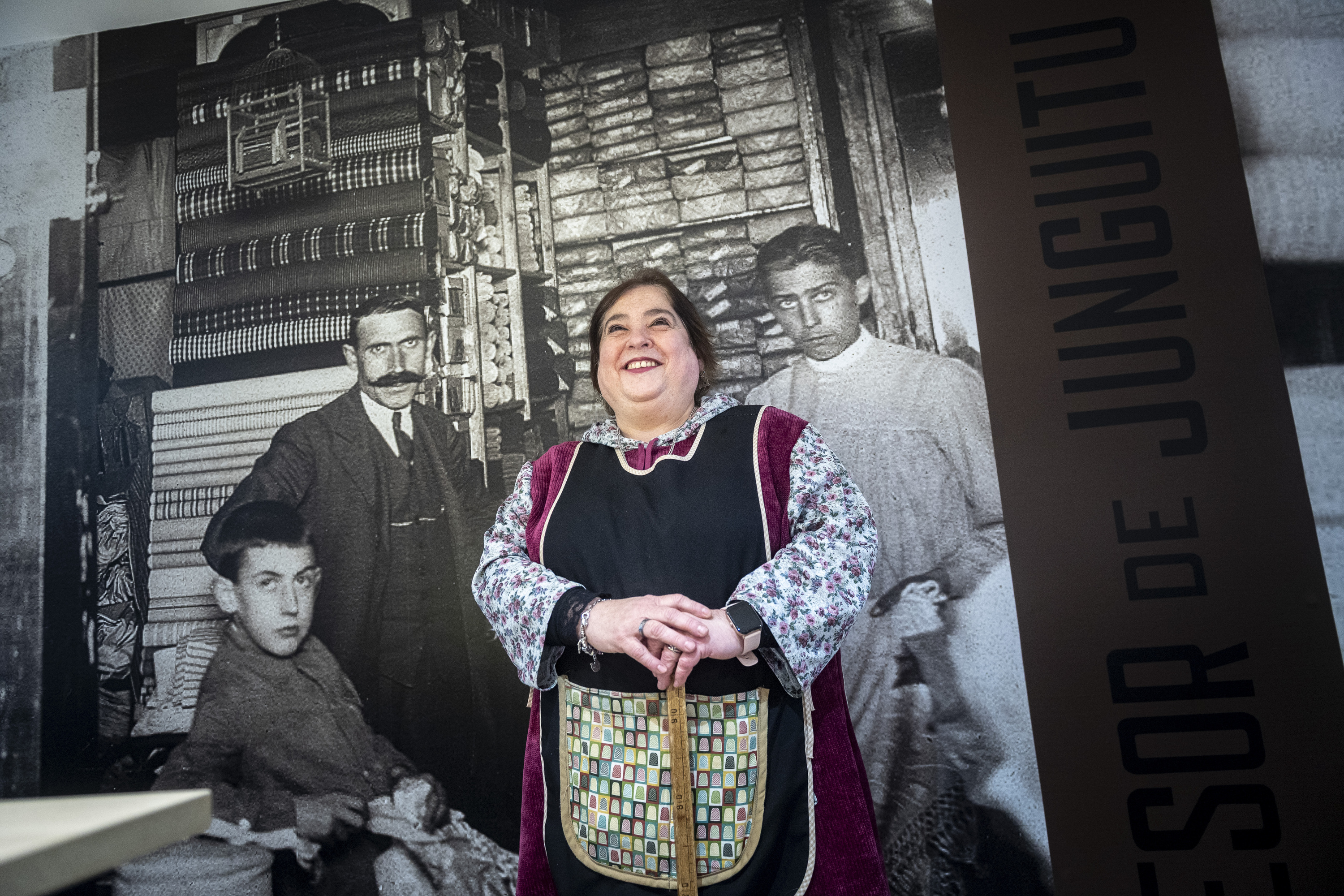  Claudia Cormenzana, Gasteizko Sucesores de Junguitu oihal dendan, atzean bere aitona, aita eta haien ikasle bat agertzen diren argazkia duela. JAIZKI FONTANEDA / FOKU