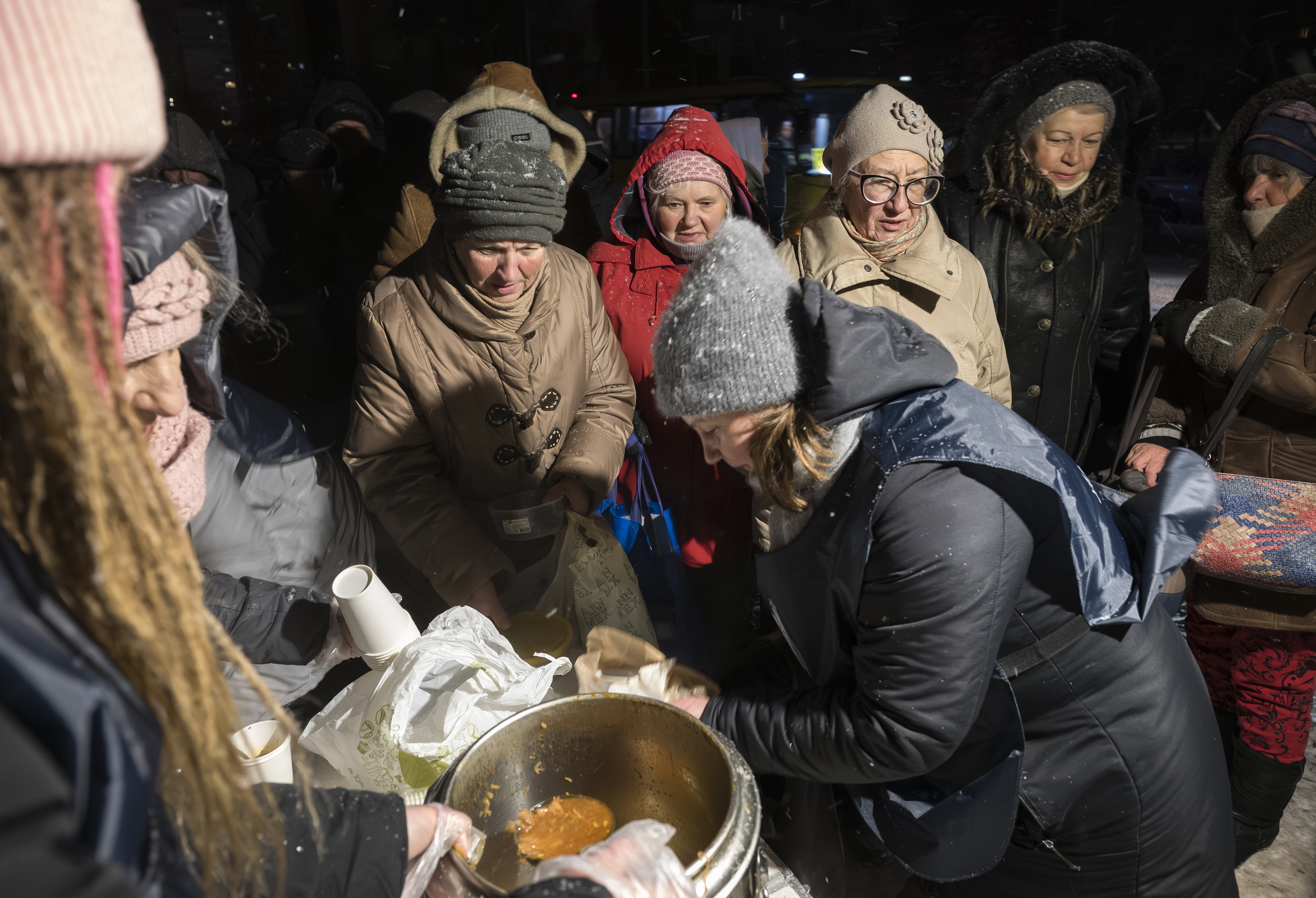 Ukrainako armadako kideak Kieveko herritarren artean bazkaria banatzen, erasoen ondoren. MAXYM MARUSENKO / EFE
