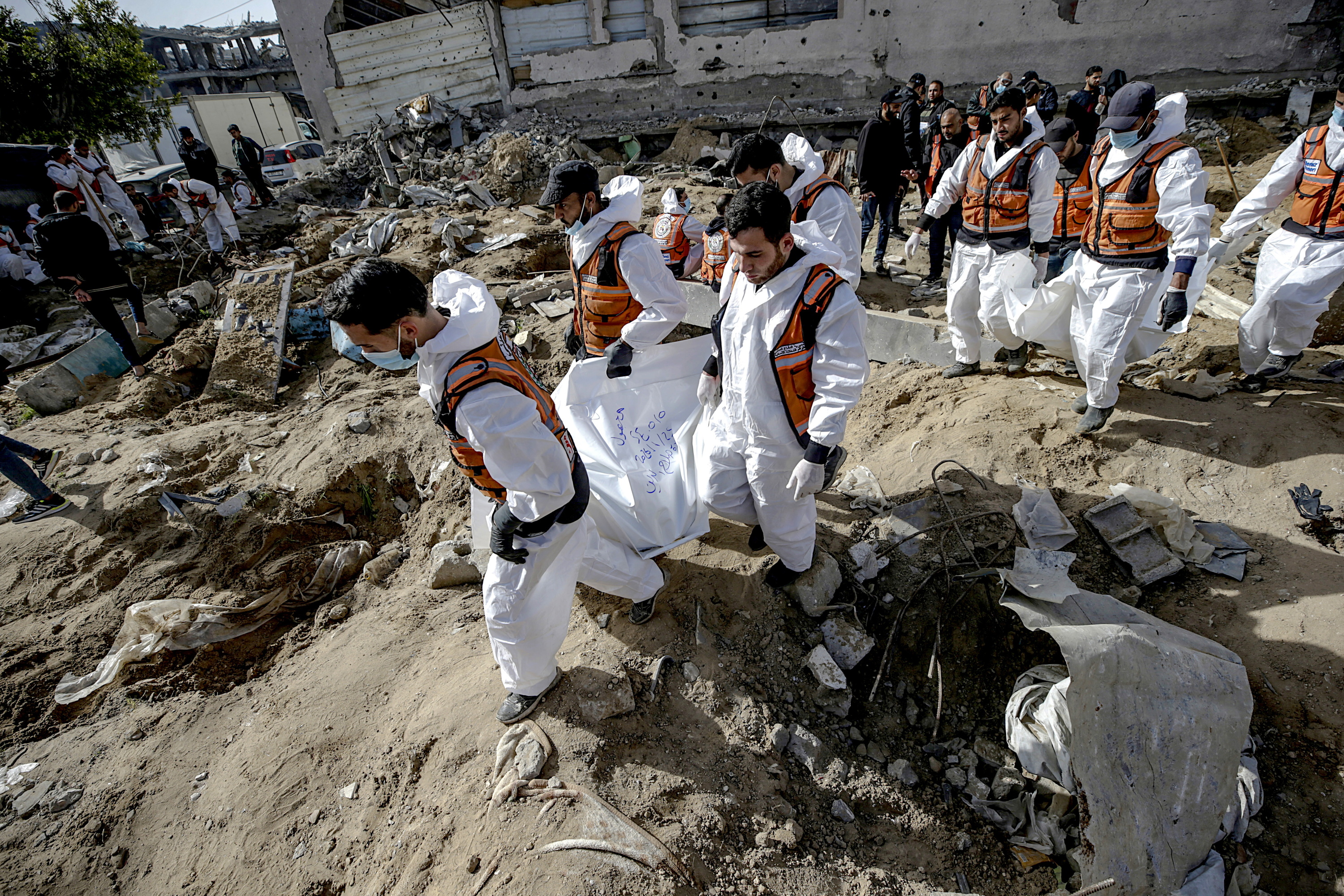 Palestinako zerbitzuak hildako pertsonen gorpuak jasotzen, atzo Gaza hirian. MOHAMMED SABER / EFE