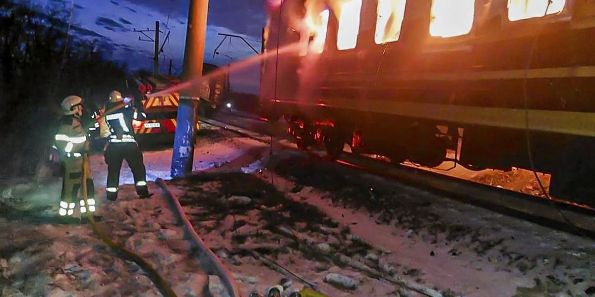 Ukrainako suhiltzaileak Errusiako armadak bonbardatutako tren batean piztutako sutea itzaltzen, atzo, Kharkiv eskualdean. EFE