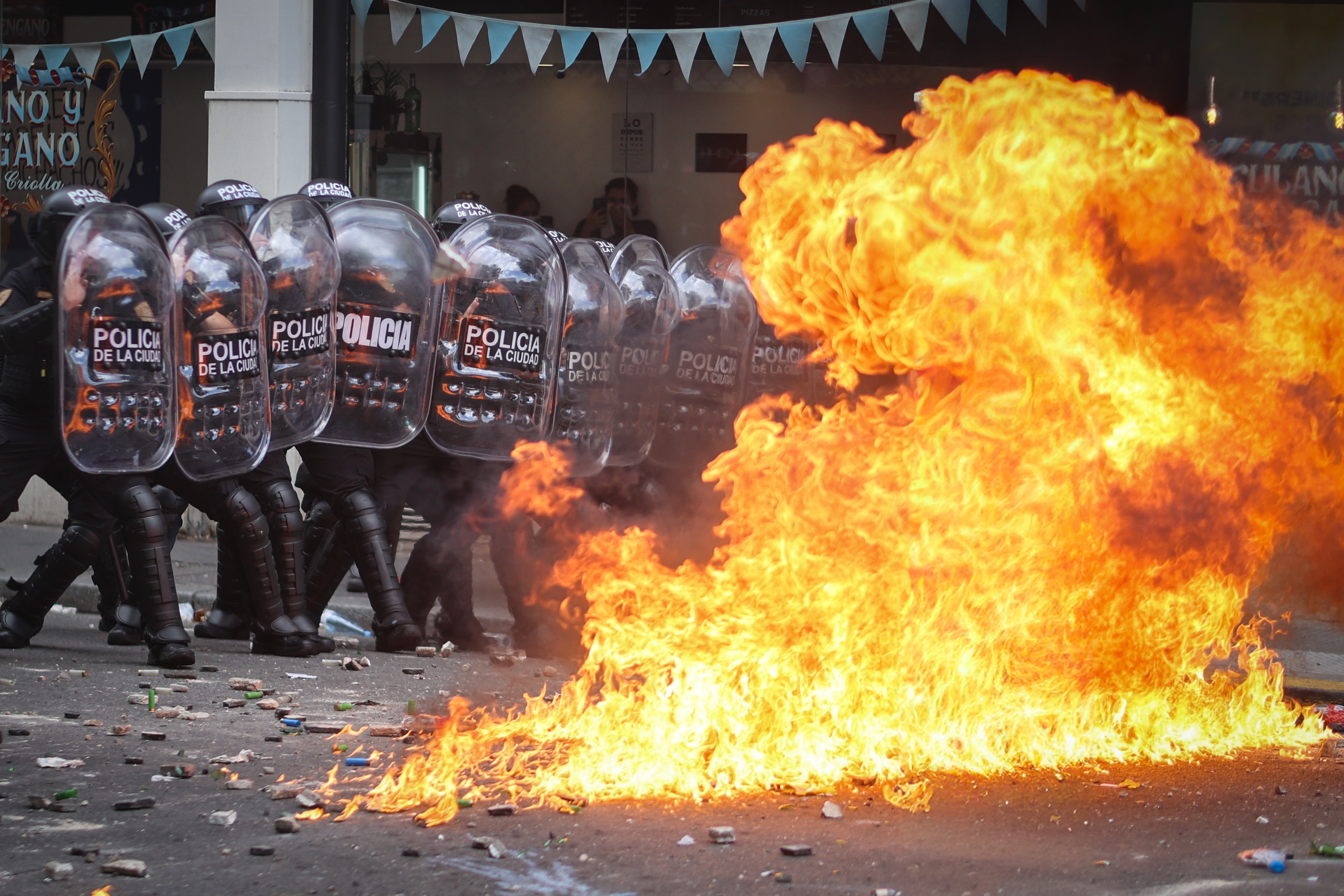 Argentinako Polizia ezkutuen atzean gordeta, manifestariekin izandako istiluetan. JUAN IGNACIO RONCORONI / EFE