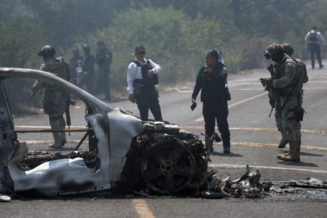 Moreliako Polizia eta Mexikoko armada, erretako auto bat aztertzen. IVAN VILLANUEVA / EFE
