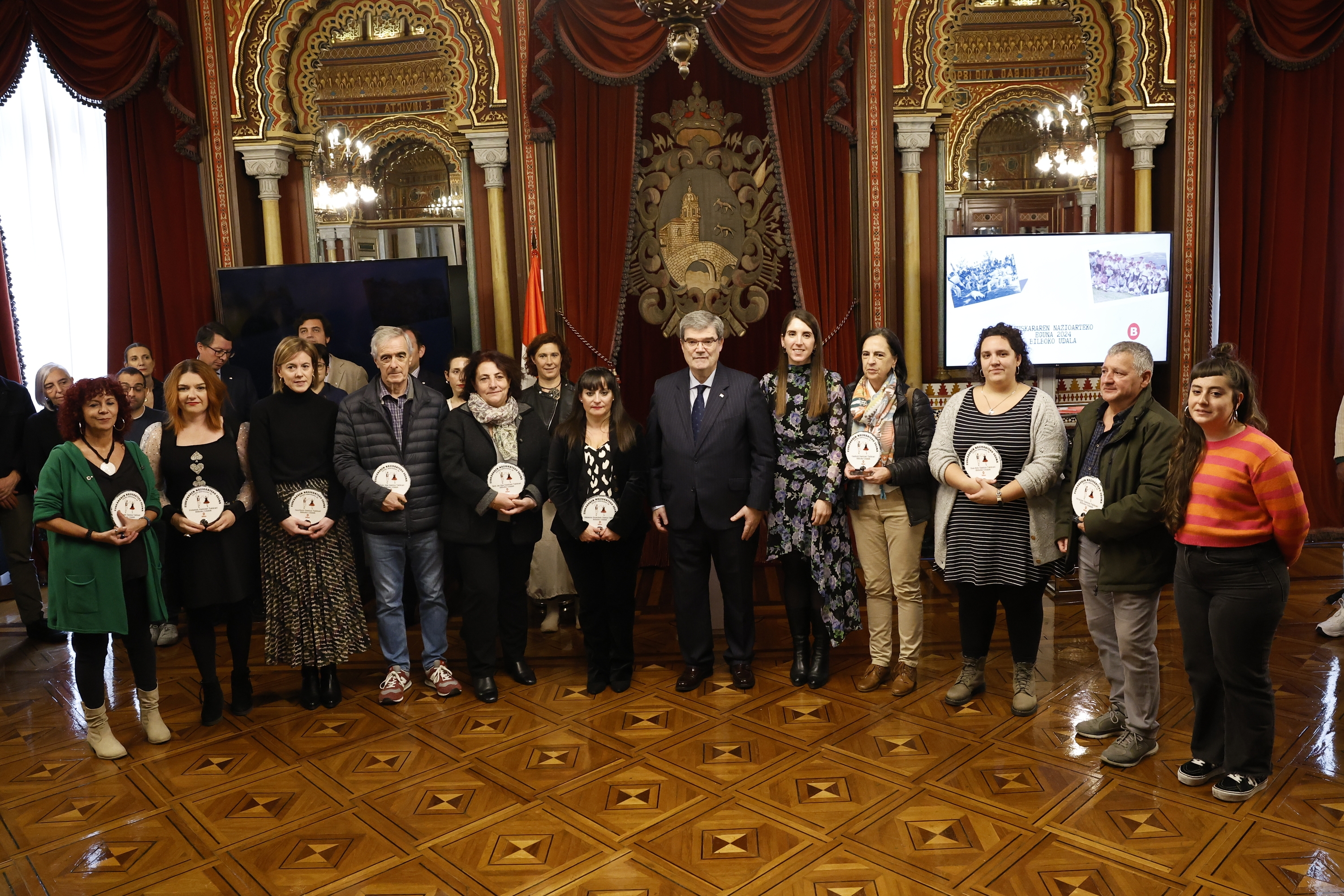 Bilboko alkate Juan Mari Aburto 2024. urteko Euskararen Egunean Bilboko Udalak omendutako pertsonekin. MIGUEL TOÑA / EFE