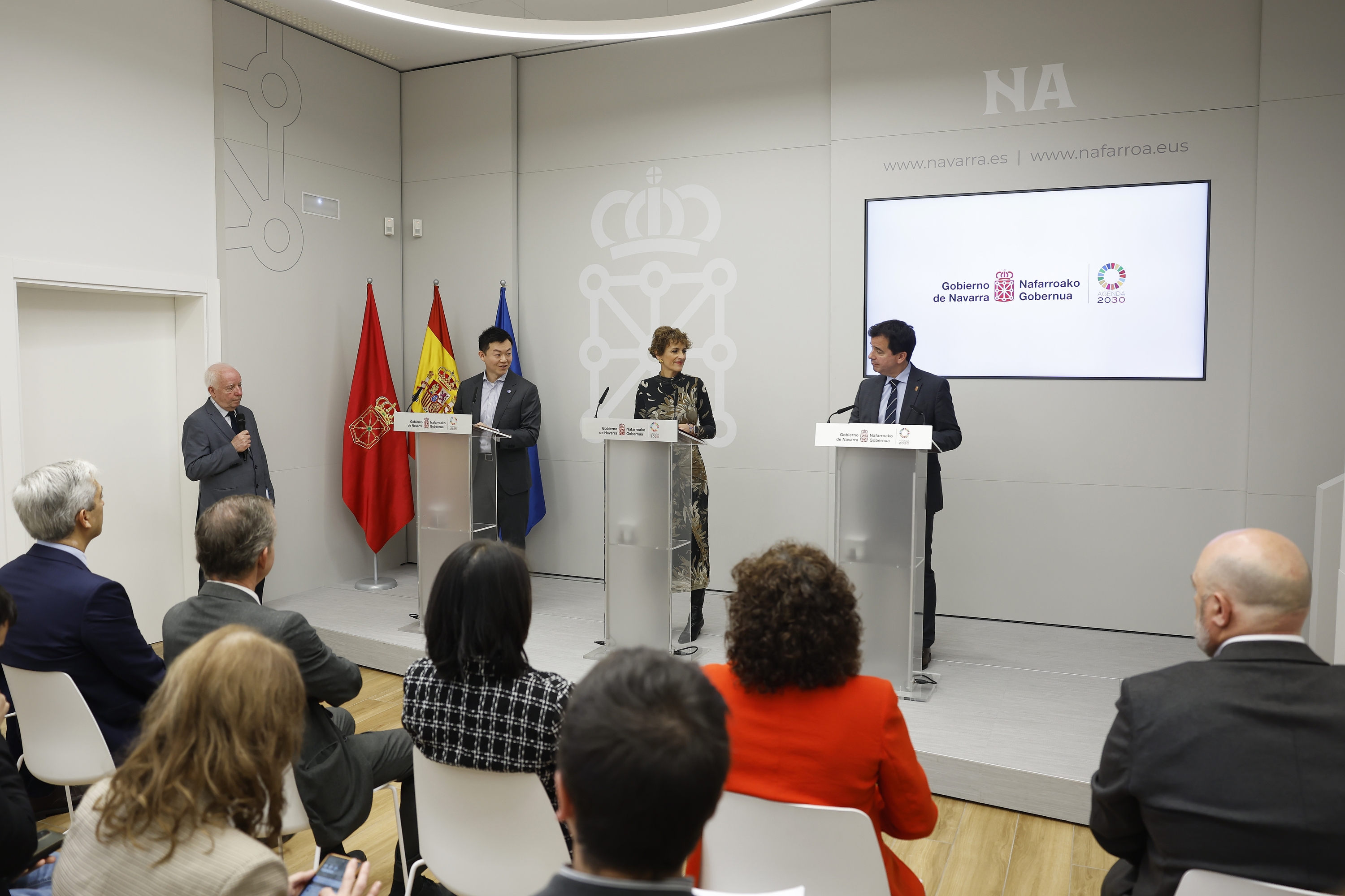 Hao Wang, Maria Txibite eta Mikel Irujo. Lehen planoan Sodenako eta gobernuko ordezkariak, gaurko agerraldian. JESUS DIGES / EFE