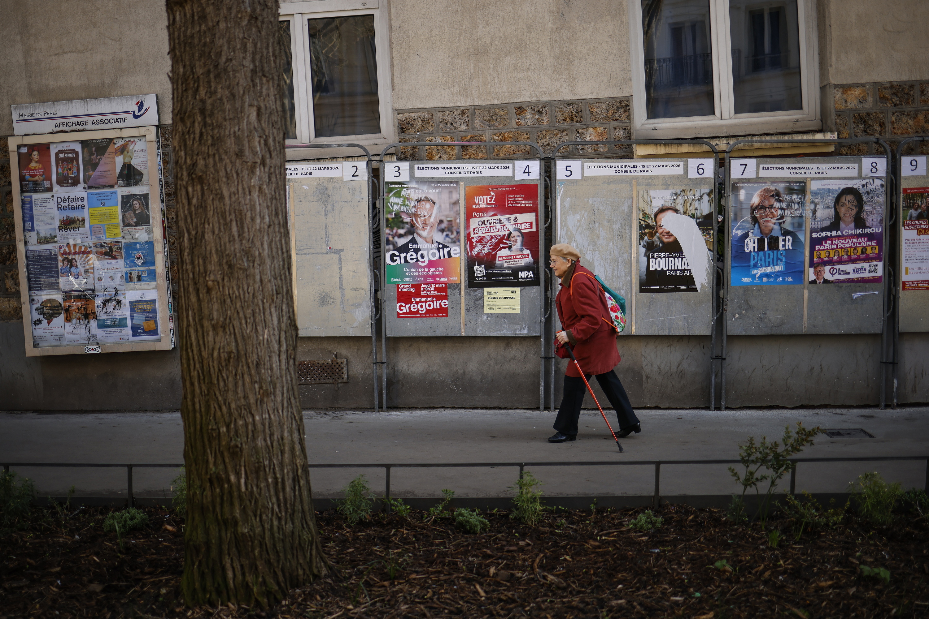 Andre bat Parisko herriko etxerako hautagaien kartelen ondotik pasatzen, aste honetan. YOAN VALAT / EFE
