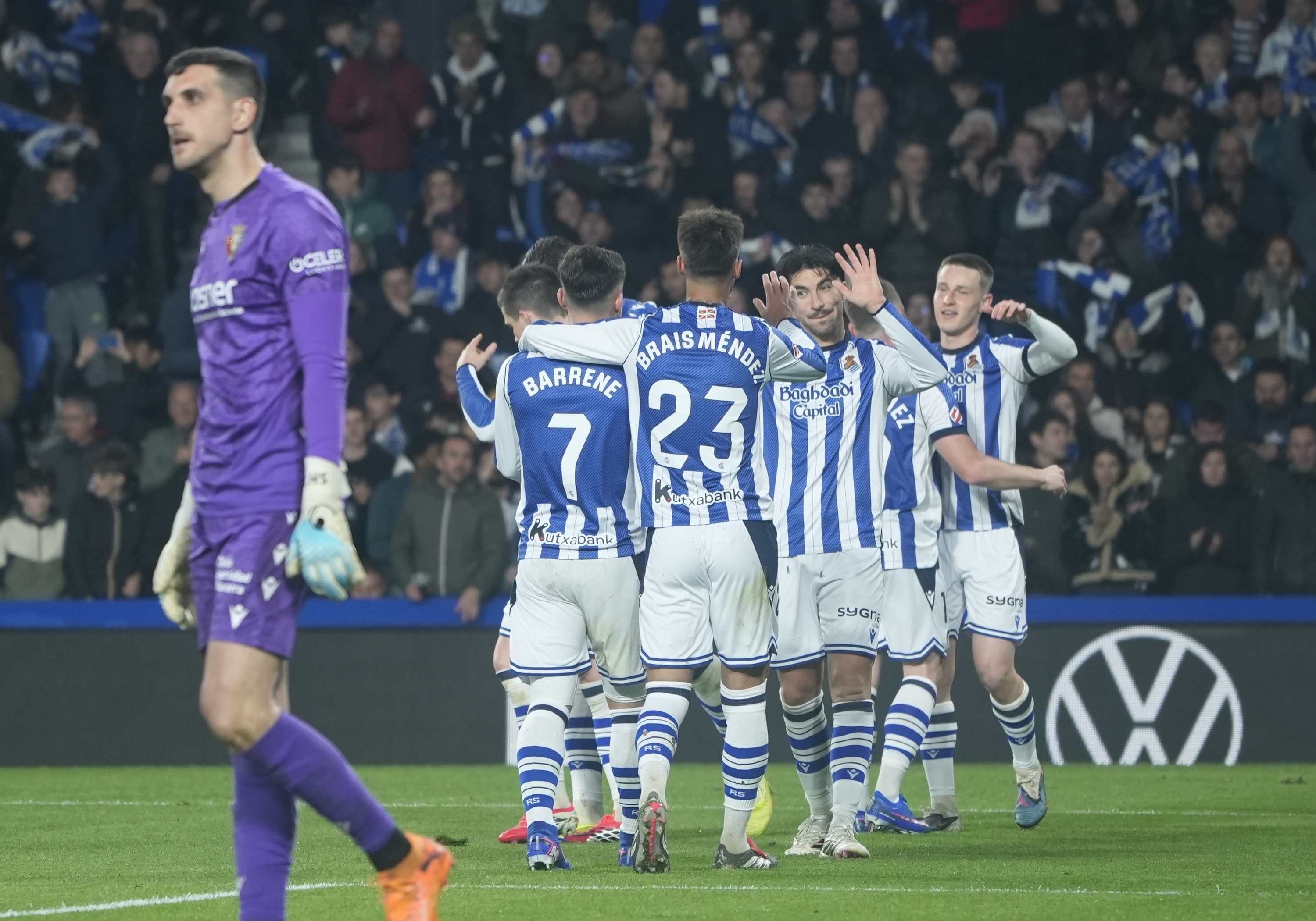 Sergio Herrera Osasunako atezaina burumakur, atzean Realeko jokalariak goletako bat ospatzen ari direla. ANDONI CANELLADA / FOKU