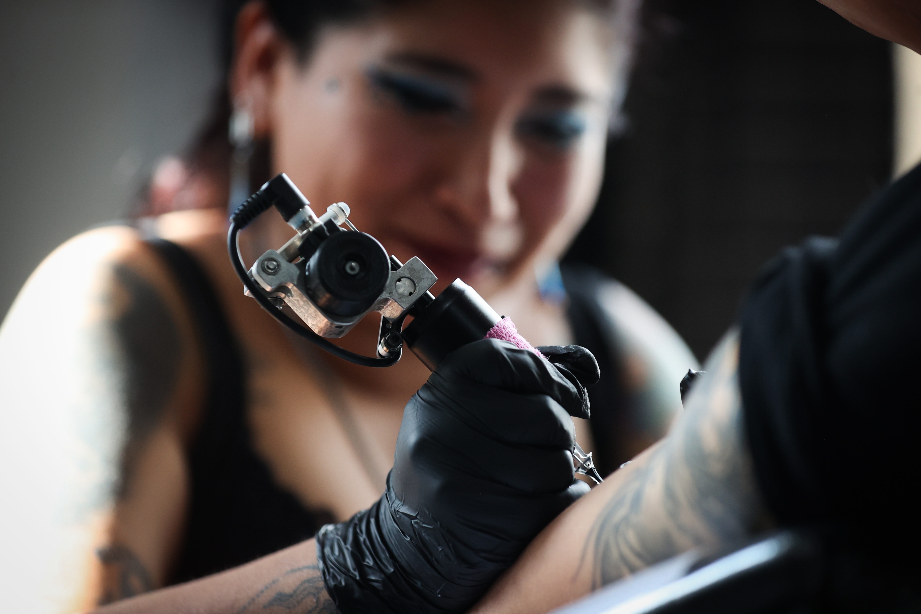 Tatuatzaile bat lanean, bezero baten besoa tatuatzen. LUIS GANDARILLAS / EFE