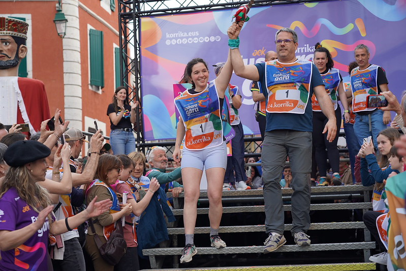 Xarlot Etxeberri eta Ximun Karrere, oholtzatik jaisten lekukoa eskutan dutela, Korrikaren hasieran. AEK