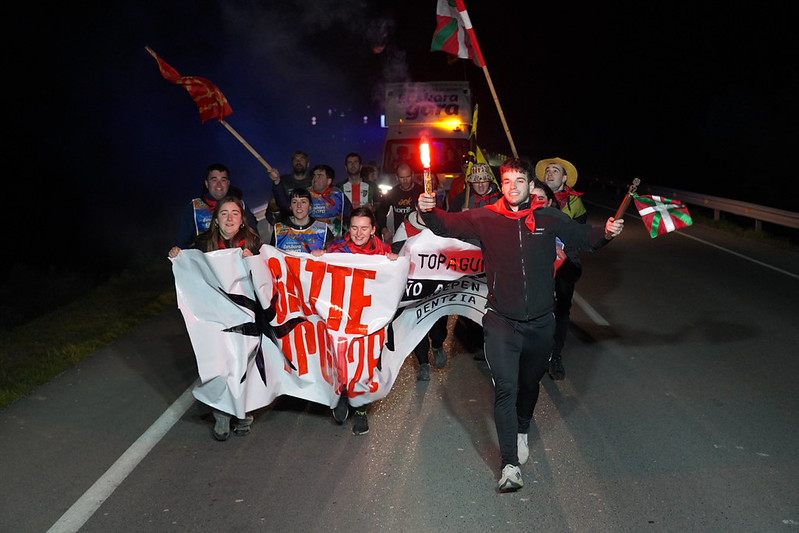 Gizon bat, lekukoa eta bengala bat eskuetan dituela. AEK