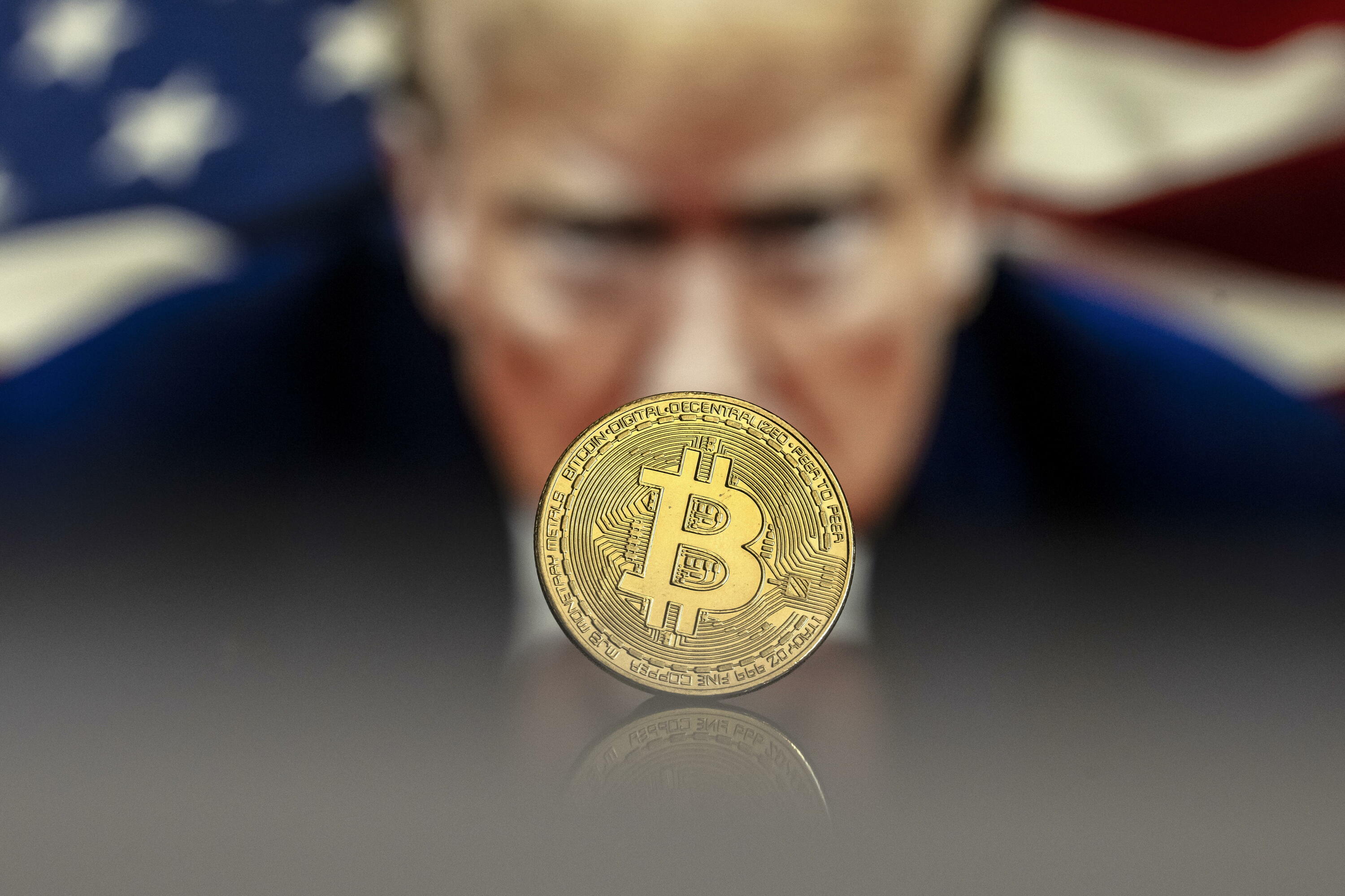 Bitcoin kriptodiruaren ikurra, Donald Trump AEBetako presidentearen irudi baten aurrean. PABLO GIAMINAZZI / EFE