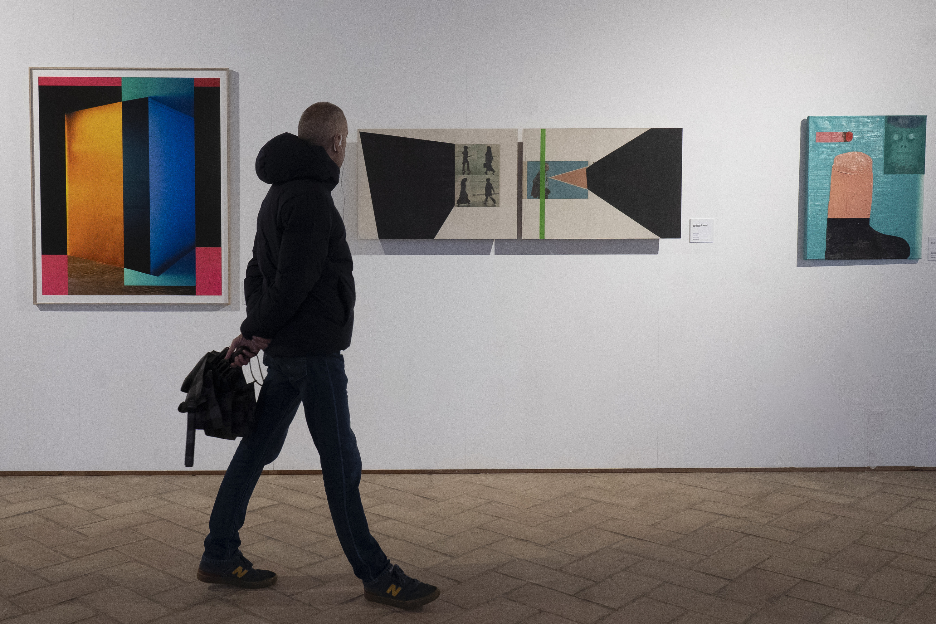 Herritar bat, Iruñeko Kondestablearen jauregian jarri duten 'Artea Oinez' erakusketako lanetako batzuei so. IÑIGO URIZ / FOKU