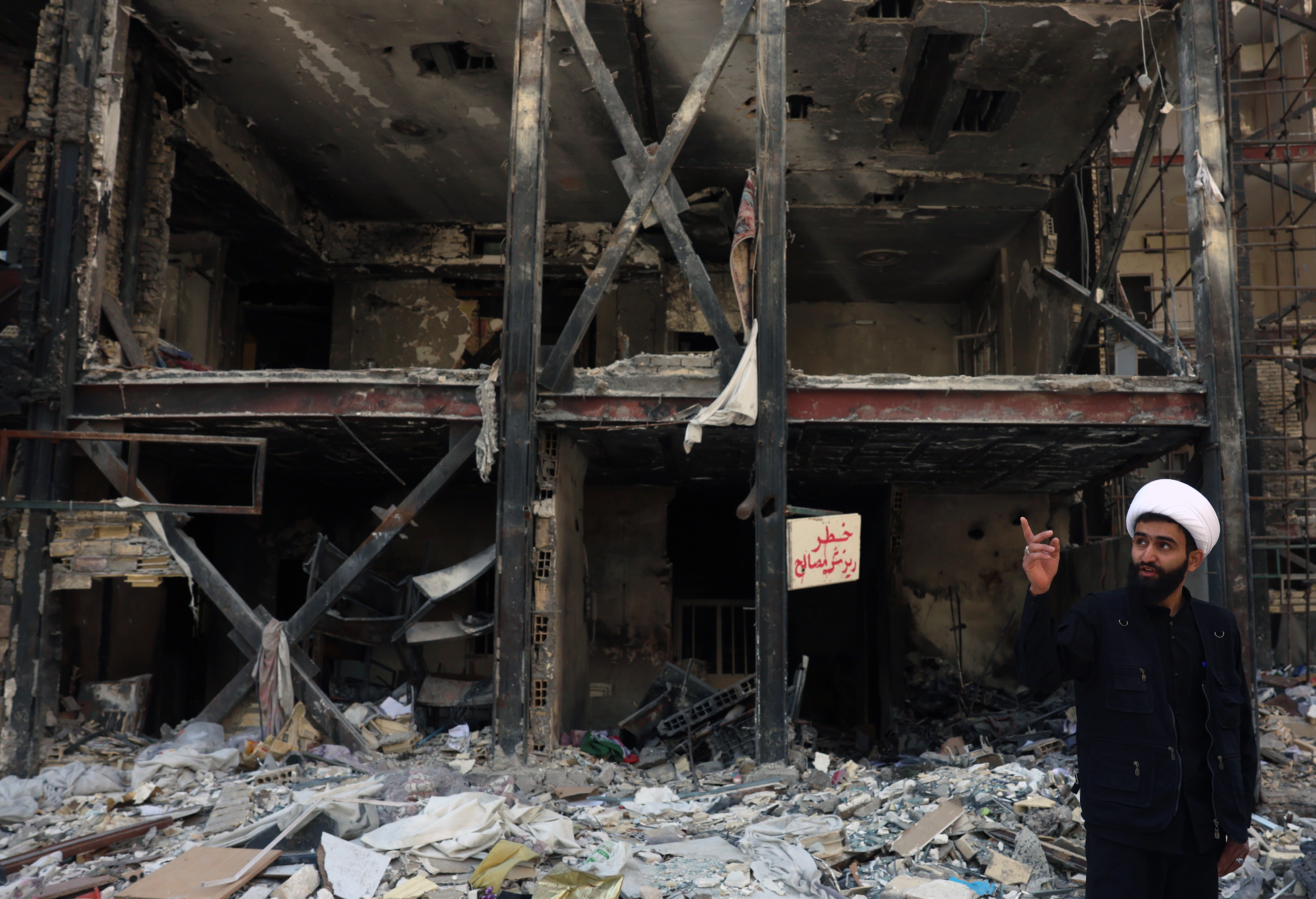 Teherango herritar bat, atzo, AEBen eta Israelen erasoek birrindutako eraikin batean, Irango hiriburuaren hegoaldean. ABEDIN TAHERKENAREH / EFE