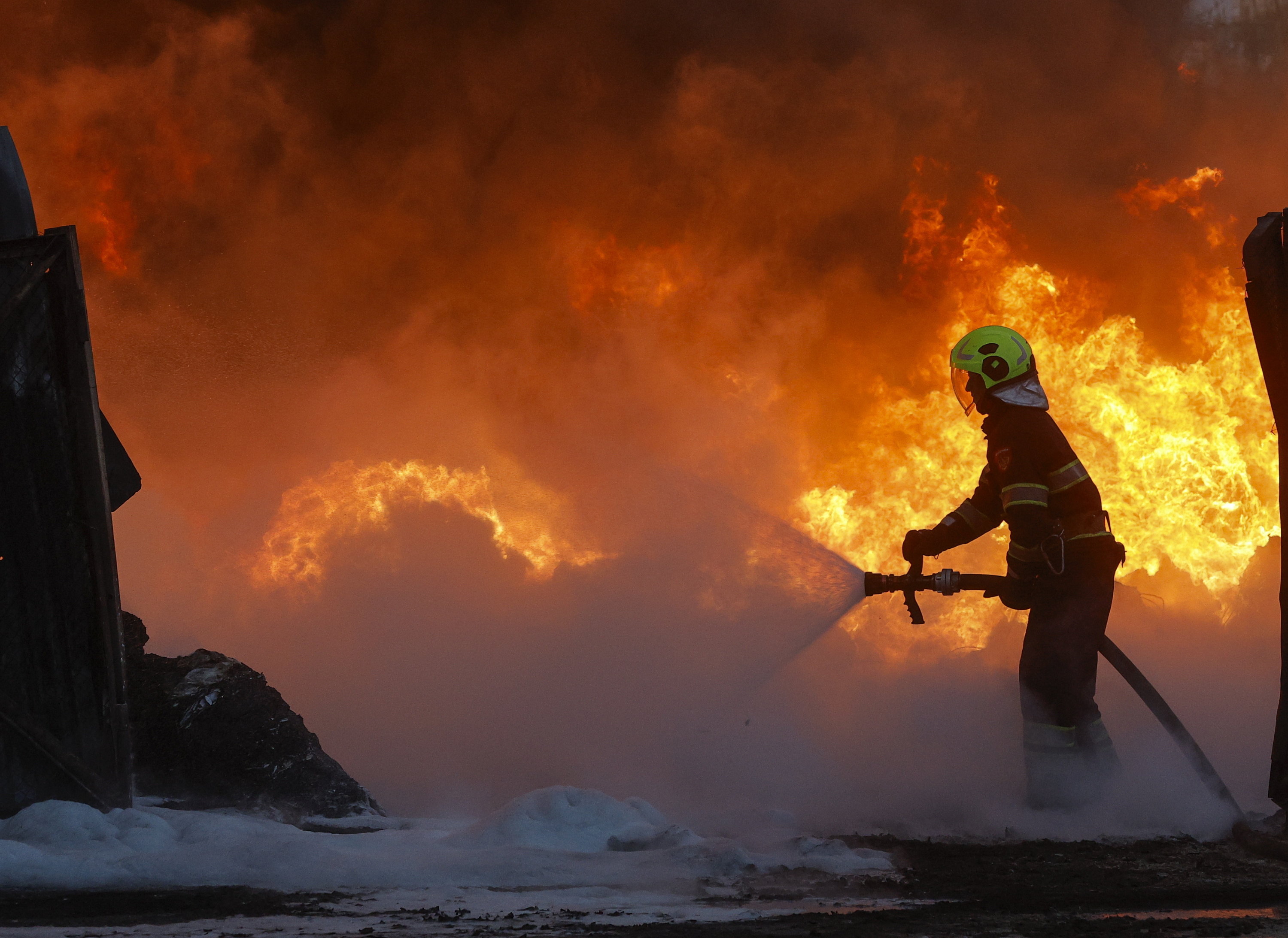 Suhiltzaile bat gaur Kieven, Errusiaren eraso batek eragindako sute bat itzaltzeko ahaleginean. SERGEY DOLZHENKO / EFE