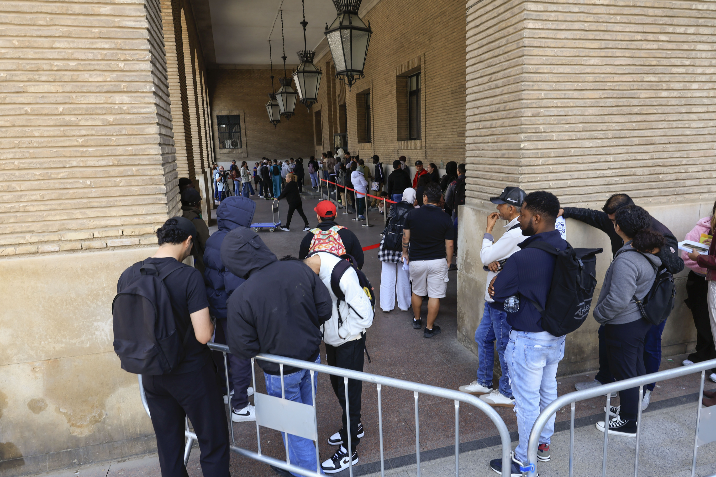 Migratzaile batzuk erregularizazioari buruzko zalantzak argitzeko ilaran, artxiboko irudi batean. JAVIER CEBOLLADA / EFE