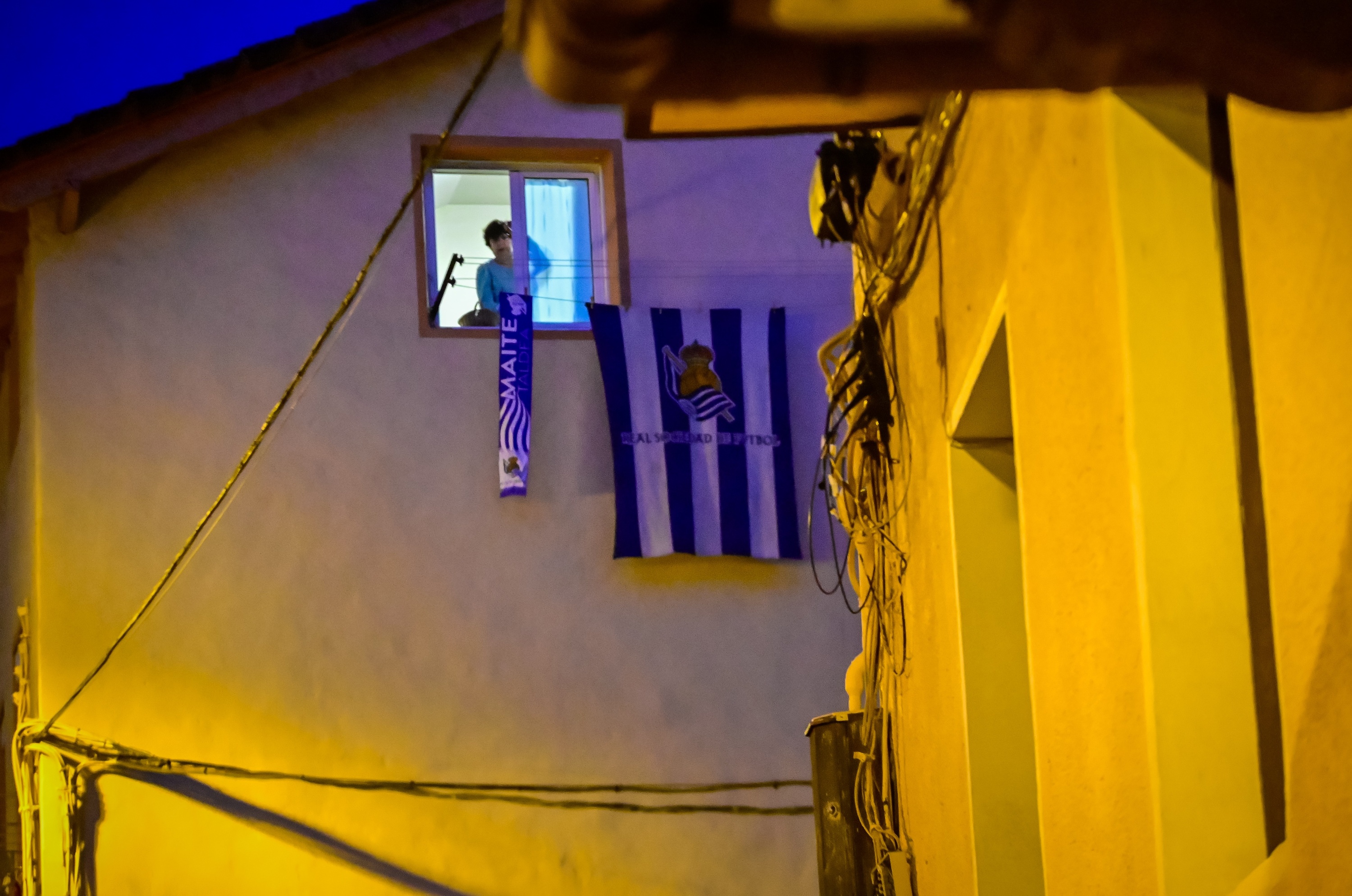 Emakume bat goizean goiz Realeko bufanda eta bandera zabaltzen, Donostian. GORKA RUBIO / FOKU