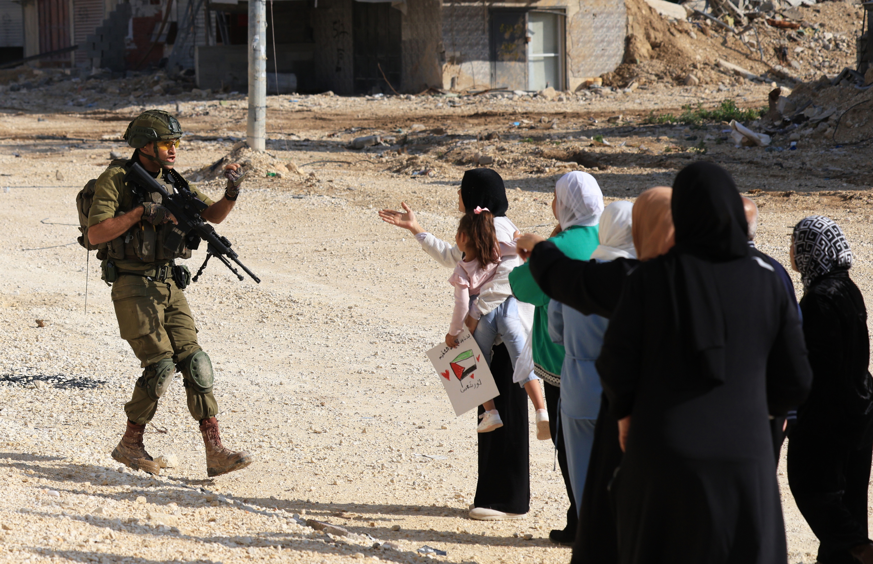 Israelgo armadako kide bat Palestinako emakume batzuekin eztabaidan, iaz, Zisjordanian. ALAA BADARNEH / EFE
