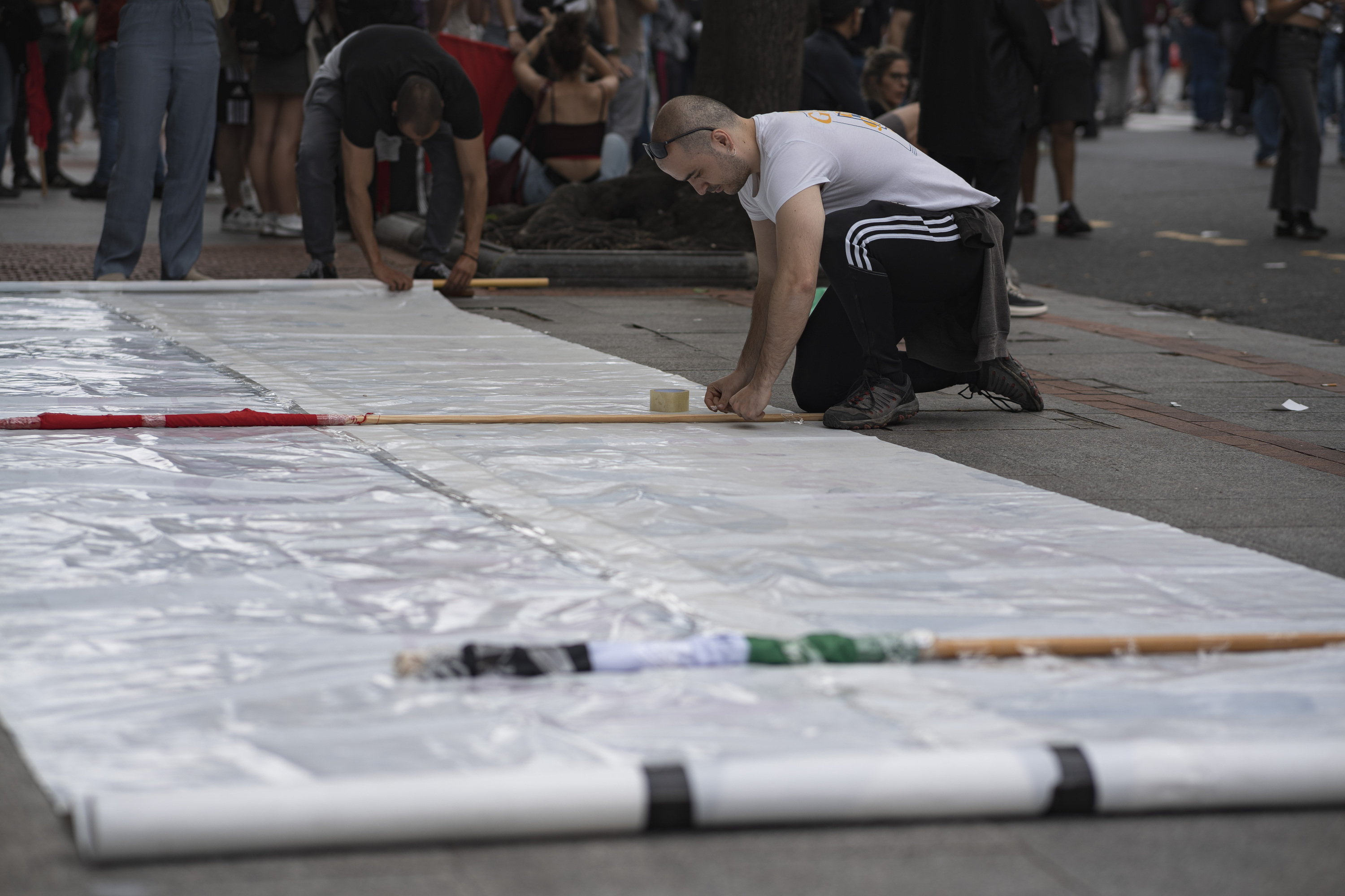 Gazte bat Maiatzaren Leheneko mobilizazio bateko pankarta bat zabaltzen, iaz, Bilbon. ARITZ LOIOLA / FOKU