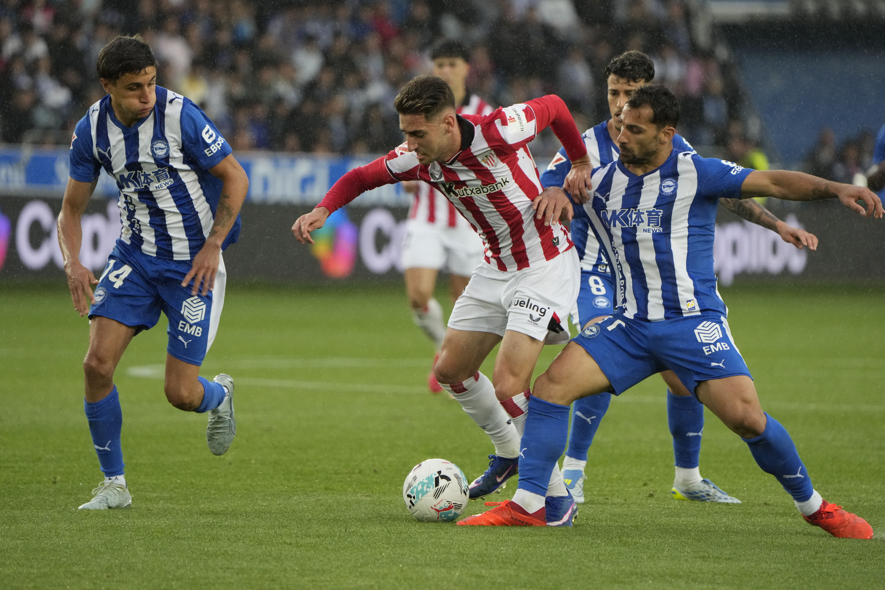 Athleticeko Robert Navarro, Alaveseko Tenaglia eta Toni Martinez atzean utzi nahian. ADRIAN RUIZ HIERRO / EFE