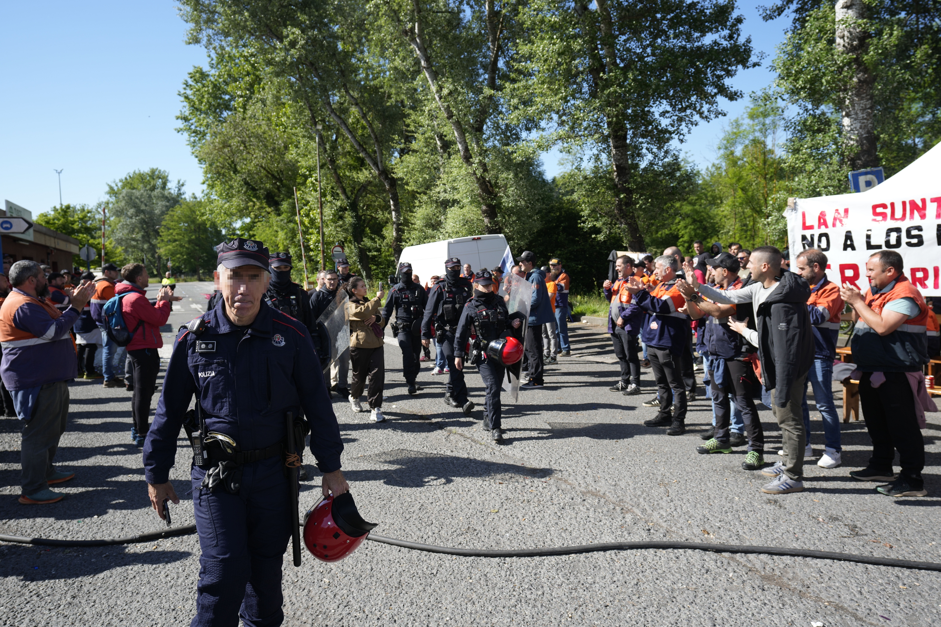 Tubos Reunidoseko langile batzuk, iragan ostegunean, batzarrean parte hartzera zihoazela, ertzainek babestuta. ADRIAN RUIZ HIERRO / EFE 
