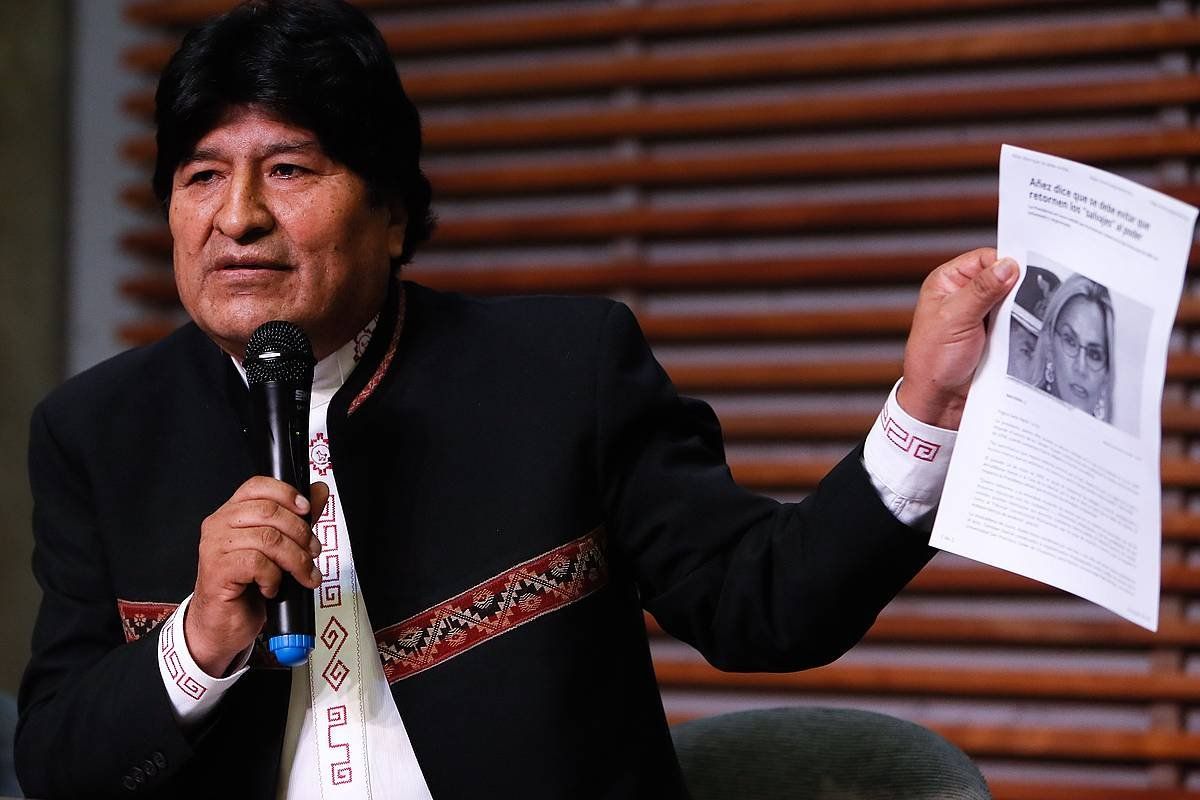 Boliviako presidente ohi Evo Morales, egungo estatuburu Jeanine Añezen argakia eskuetan duela. JUAN IGNACIO RONCORONI, EFE