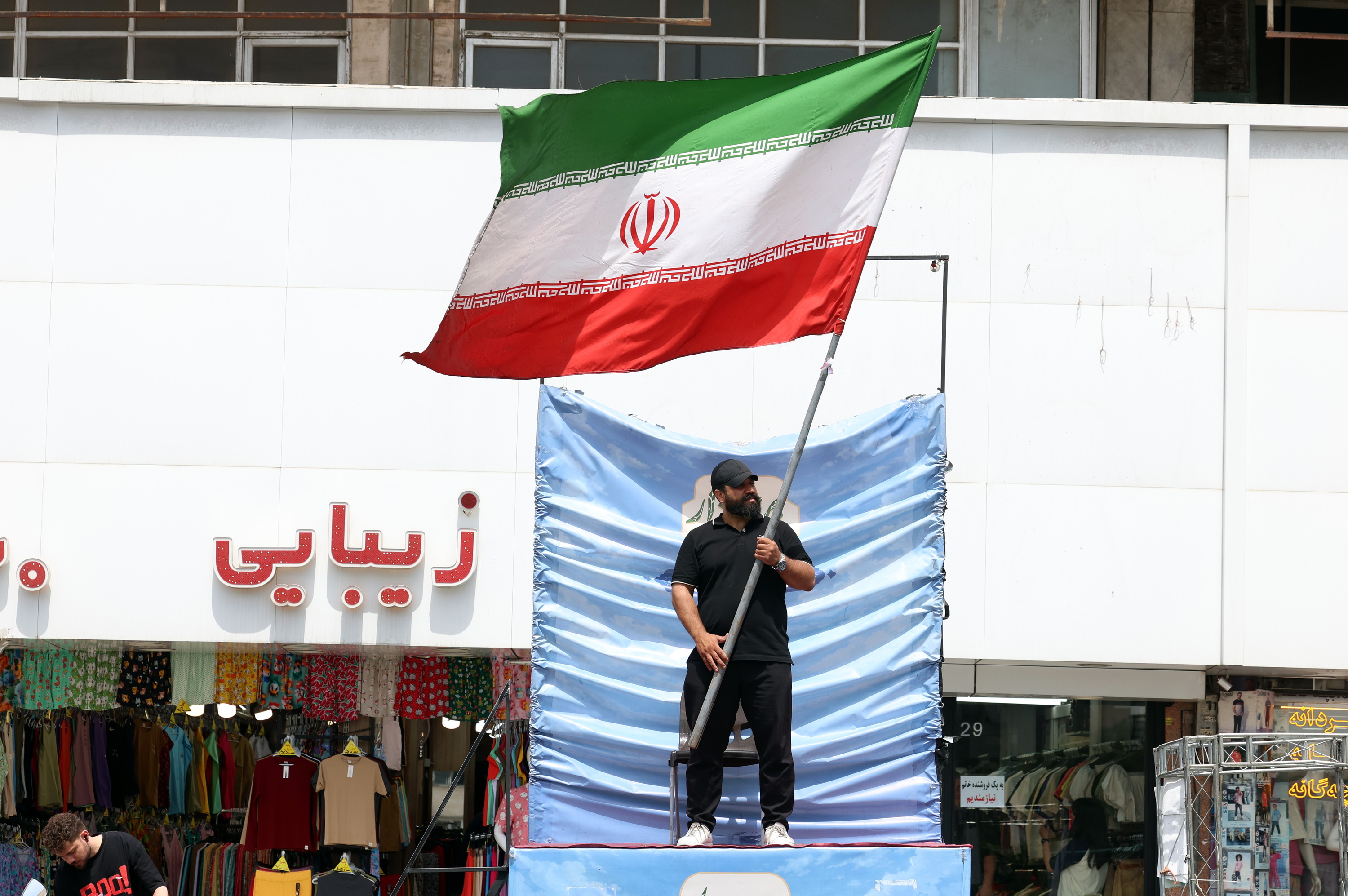 Herritar bat Irango bandera astintzen, gaur, Teheranen. ABEDIN TAHERKENAREH / EFE