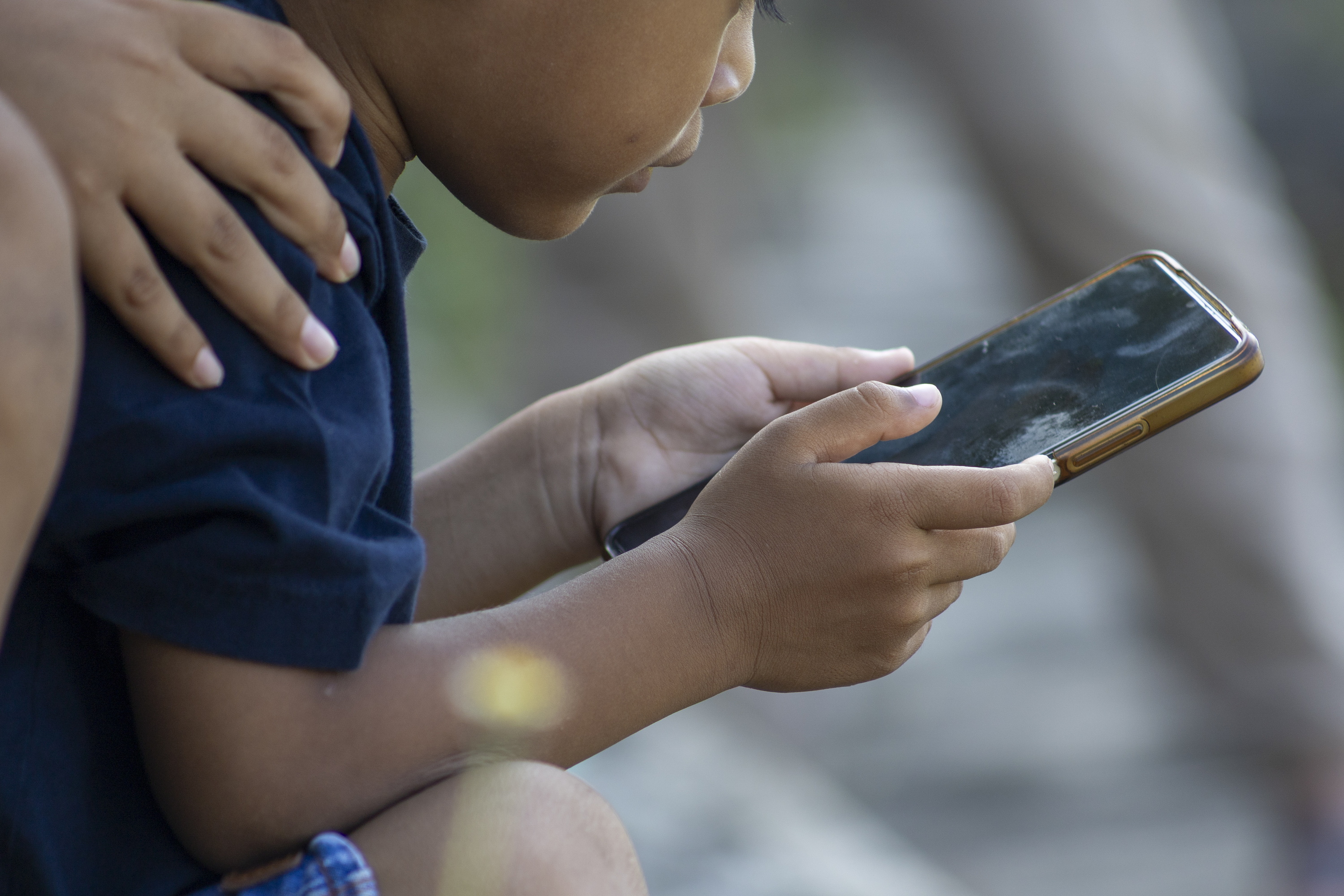 Adingabe bat sakelako telefono bat eskuetan duela Denpasarren (Indonesia), aurreko martxoan. MADE NAGI / EFE