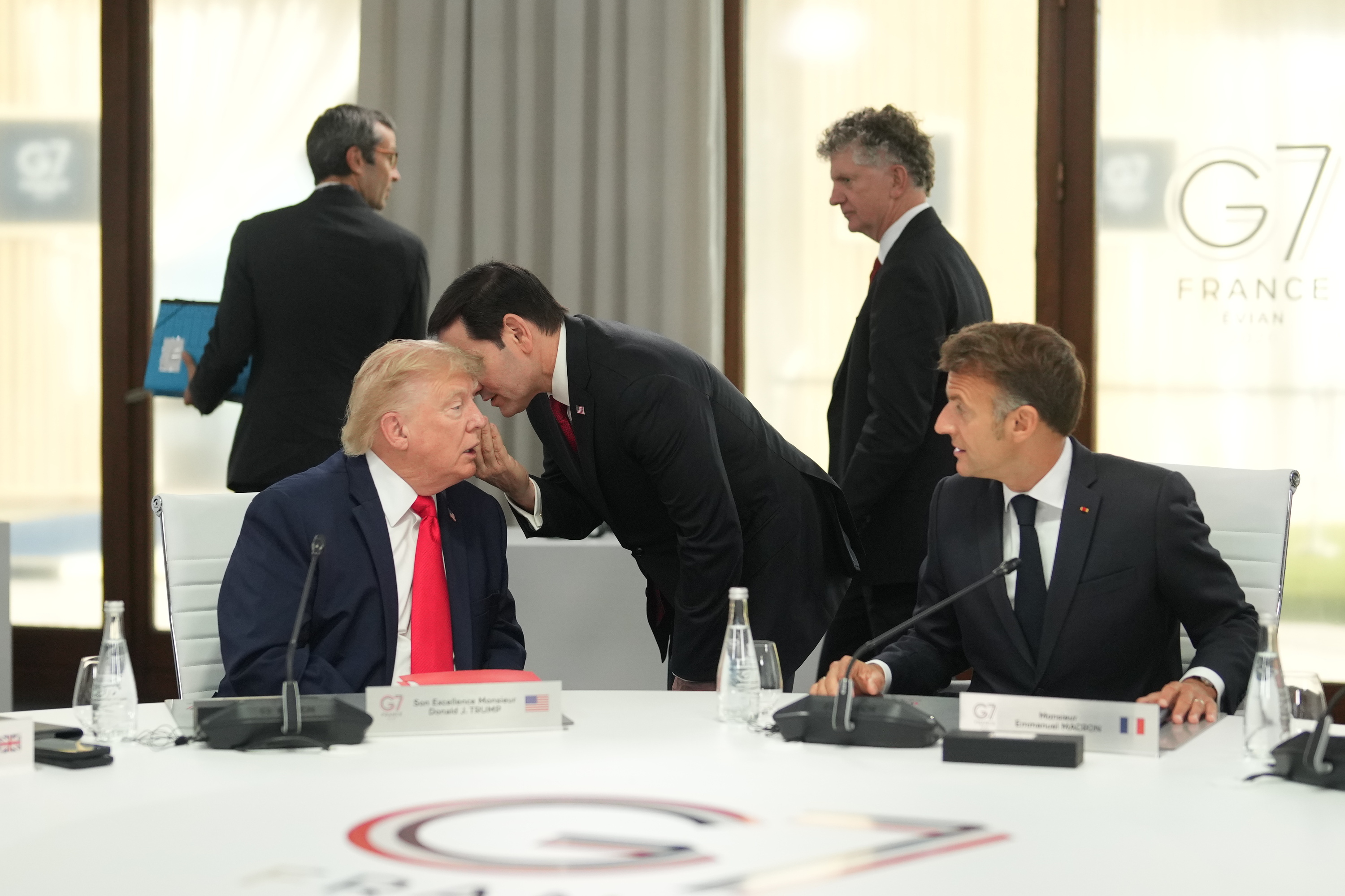 Donald Trump atzo, ezkerrean, Marco Rubio AEBetako Estatu idazkaria belarrira xuxurlatzen ari zaion bitartean, Emmanuel Macron aldamenean daukala. THIBAULT CAMUS / EFE